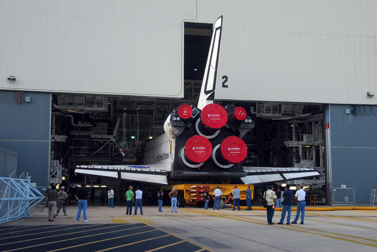 KENNEDY SPACE CENTER, FLA. --  Viewed from outside, the orbiter Endeavour rolls out of Orbiter Processing Facility bay 2 on its transporter.  It is headed for the Vehicle Assembly Building where it will be stacked with the external tank and solid rocket boosters atop the mobile launcher platform for its launch on mission STS-118. The mission will be Endeavour's first flight in more than four years. The shuttle has undergone extensive modifications, including the addition of safety upgrades already added to shuttles Discovery and Atlantis. Endeavour also features new hardware, such as the Station-to-Shuttle Power Transfer System that will allow the docked shuttle to draw electrical power from the station and extend its visits to the orbiting lab.  Endeavour is targeted for launch on Aug. 7.   Photo credit: NASA/George Shelton