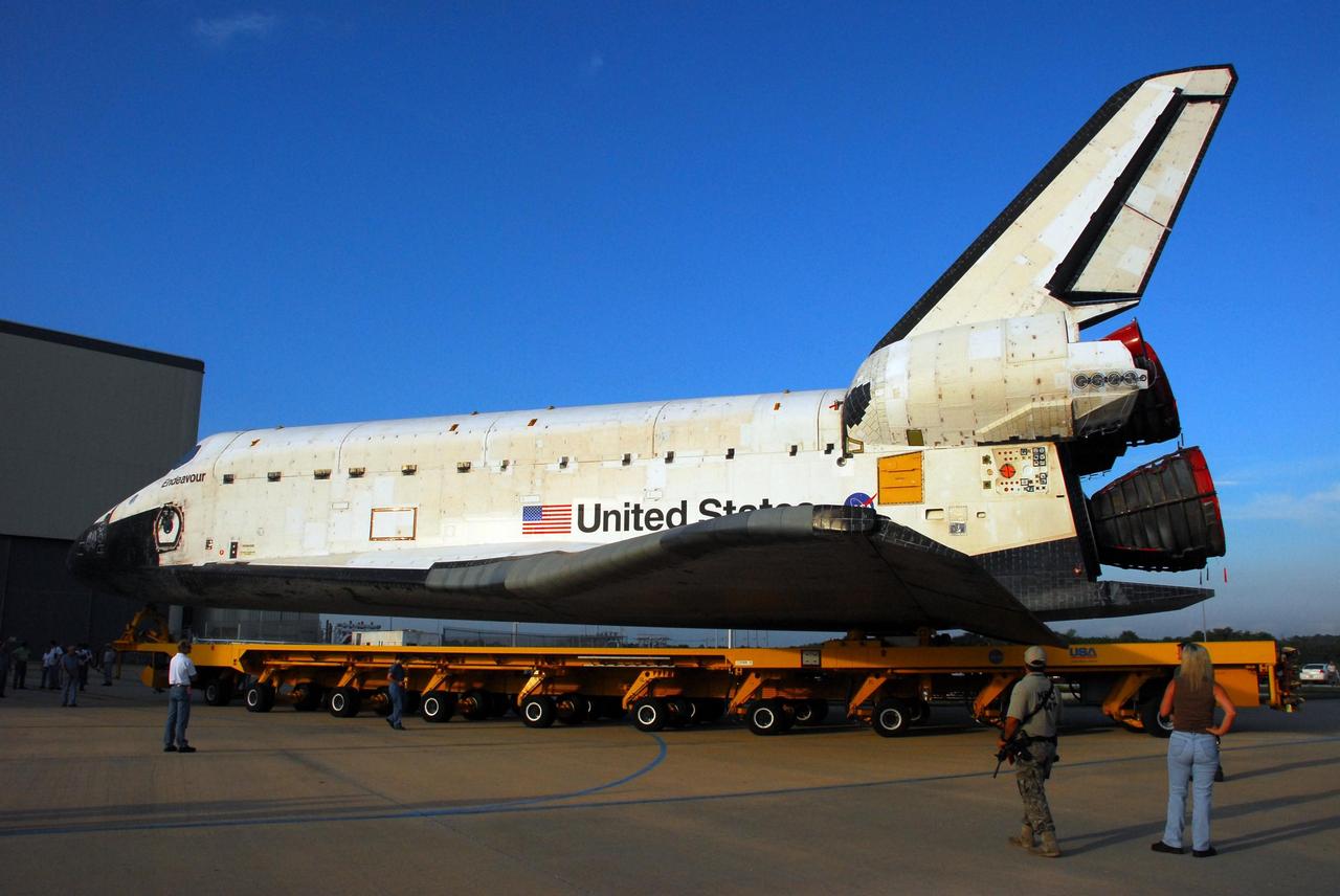 KENNEDY SPACE CENTER, FLA. --  The orbiter Endeavour rolls away from Orbiter Processing Facility bay 2 on its transporter.  It is headed for the Vehicle Assembly Building where it will be stacked with the external tank and solid rocket boosters atop the mobile launcher platform for its launch on mission STS-118. The mission will be Endeavour's first flight in more than four years. The shuttle has undergone extensive modifications, including the addition of safety upgrades already added to shuttles Discovery and Atlantis. Endeavour also features new hardware, such as the Station-to-Shuttle Power Transfer System that will allow the docked shuttle to draw electrical power from the station and extend its visits to the orbiting lab.  Endeavour is targeted for launch on Aug. 7.   Photo credit: NASA/George Shelton