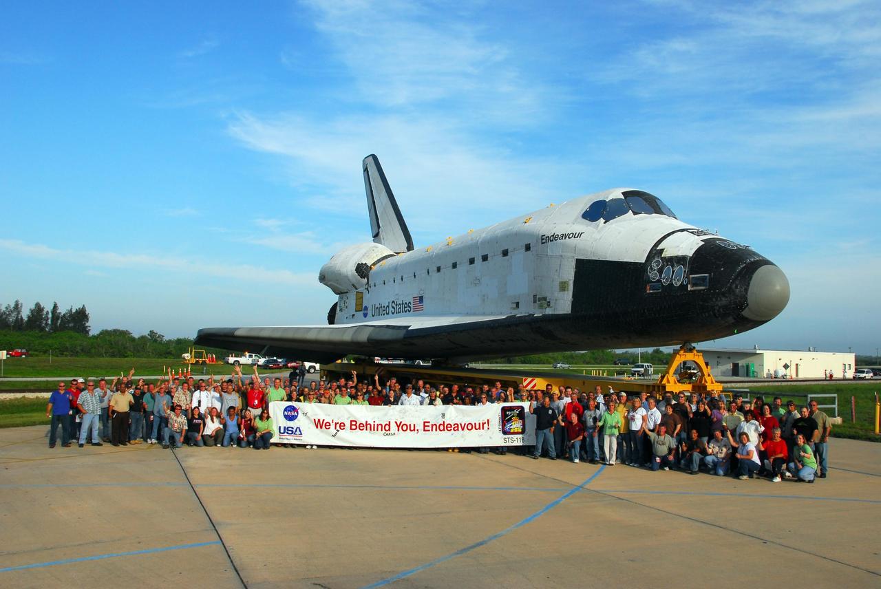 KENNEDY SPACE CENTER, FLA. -- The Endeavour team gathers for a final farewell as the orbiter gets ready to roll to the Vehicle Assembly Building. In the VAB, it will be stacked with the external tank and solid rocket boosters atop the mobile launcher platform for its launch on mission STS-118. The mission will be Endeavour's first flight in more than four years. The shuttle has undergone extensive modifications, including the addition of safety upgrades already added to shuttles Discovery and Atlantis. Endeavour also features new hardware, such as the Station-to-Shuttle Power Transfer System that will allow the docked shuttle to draw electrical power from the station and extend its visits to the orbiting lab. Endeavour is targeted for launch on Aug. 7. Photo credit: NASA/George Shelton