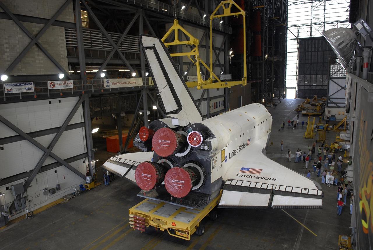 KENNEDY SPACE CENTER, FLA. -- The orbiter Endeavour, atop its transporter, stops under the overhead crane in the transfer aisle of the Vehicle Assembly Building. In the VAB, the crane will lift the orbiter then lower it onto the mobile launcher platform where it will be stacked with the external tank and solid rocket boosters for launch on mission STS-118. The mission will be Endeavour's first flight in more than four years. The shuttle has undergone extensive modifications, including the addition of safety upgrades already added to shuttles Discovery and Atlantis. Endeavour also features new hardware, such as the Station-to-Shuttle Power Transfer System that will allow the docked shuttle to draw electrical power from the station and extend its visits to the orbiting lab. Endeavour is targeted for launch on Aug. 7. Photo credit: NASA/Kim Shiflett