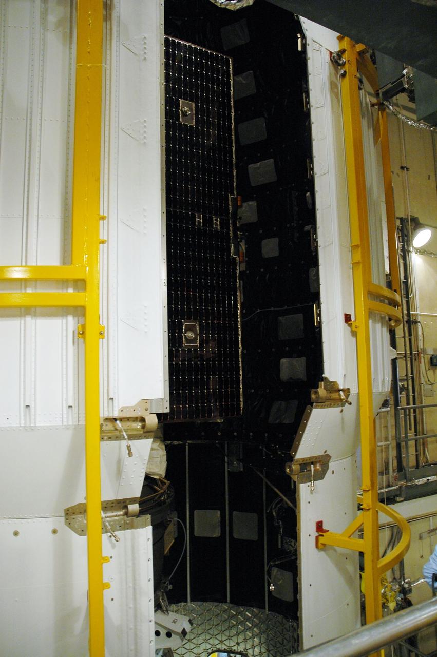 KENNEDY SPACE CENTER, FLA. --    On Launch Pad 17-B at Cape Canaveral Air Force Station in Florida, the second half of the fairing moves toward NASA's Dawn spacecraft to complete encapsulation. The fairing is a molded structure that fits flush with the outside surface of the Delta II upper stage booster and forms an aerodynamically smooth nose cone, protecting the spacecraft during launch and ascent. Dawn's goal is to characterize the conditions and processes of the solar system's earliest epoch 4.5 billion years ago by investigating in detail two of the largest asteroids, Ceres and Vesta. They reside between Mars and Jupiter in the asteroid belt.  Launch is scheduled for July 8.  Photo credit: NASA/Amanda Diller