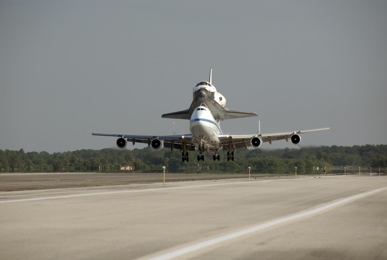 KENNEDY SPACE CENTER, FLA. -- The shuttle carrier aircraft, or SCA, and its piggyback passenger Atlantis near touchdown on the KSC Shuttle Landing Facility. The SCA is a modified Boeing 747 jetliner. Touchdown was at 8:27 a.m. EDT. Atlantis landed at Edwards Air Force Base in California to end mission STS-117. The return to KSC began July 1 and took three days after stops across the country for fuel. The last stop was at Ft. Campbell in Kentucky. Weather conditions over the last leg postponed the return trip until July 3. Atlantis will be removed from the back of the SCA via the mate/demate device at the SLF. It will then be towed to the Orbiter Processing Facility to begin processing for its next launch, mission STS-122 in December. Photo credit: NASA/Kim Shiflett