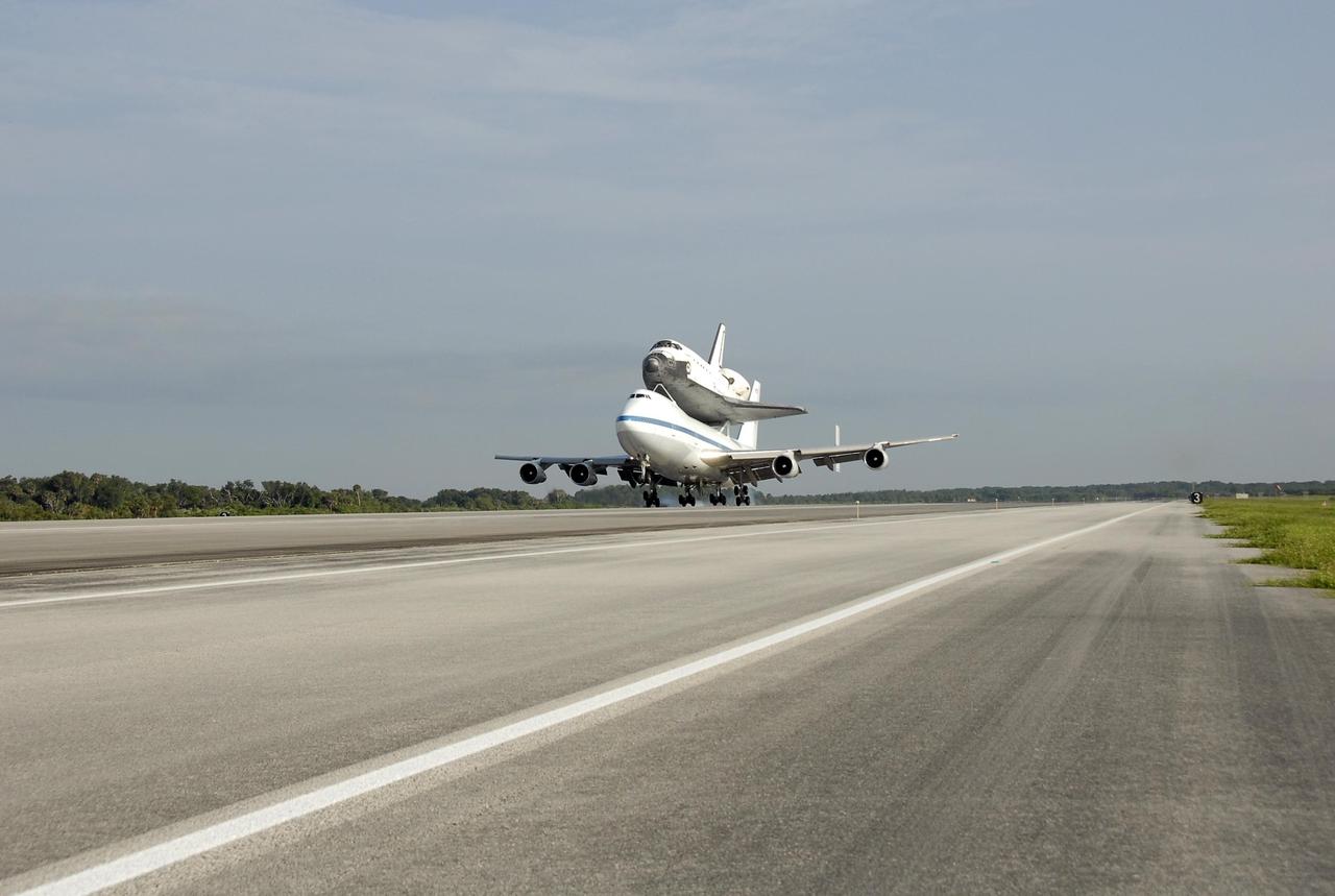 KENNEDY SPACE CENTER, FLA. -- The shuttle carrier aircraft, or SCA, and its piggyback passenger Atlantis kick up a little dust at touchdown on the KSC Shuttle Landing Facility. Touchdown was at 8:27 a.m. EDT. The SCA is a modified Boeing 747 jetliner. Atlantis landed at Edwards Air Force Base in California to end mission STS-117. The return to KSC began July 1 and took three days after stops across the country for fuel. The last stop was at Ft. Campbell in Kentucky. Weather conditions over the last leg postponed the return trip until July 3. Atlantis will be removed from the back of the SCA via the mate/demate device at the SLF. It will then be towed to the Orbiter Processing Facility to begin processing for its next launch, mission STS-122 in December. Photo credit: NASA/Kim Shiflett