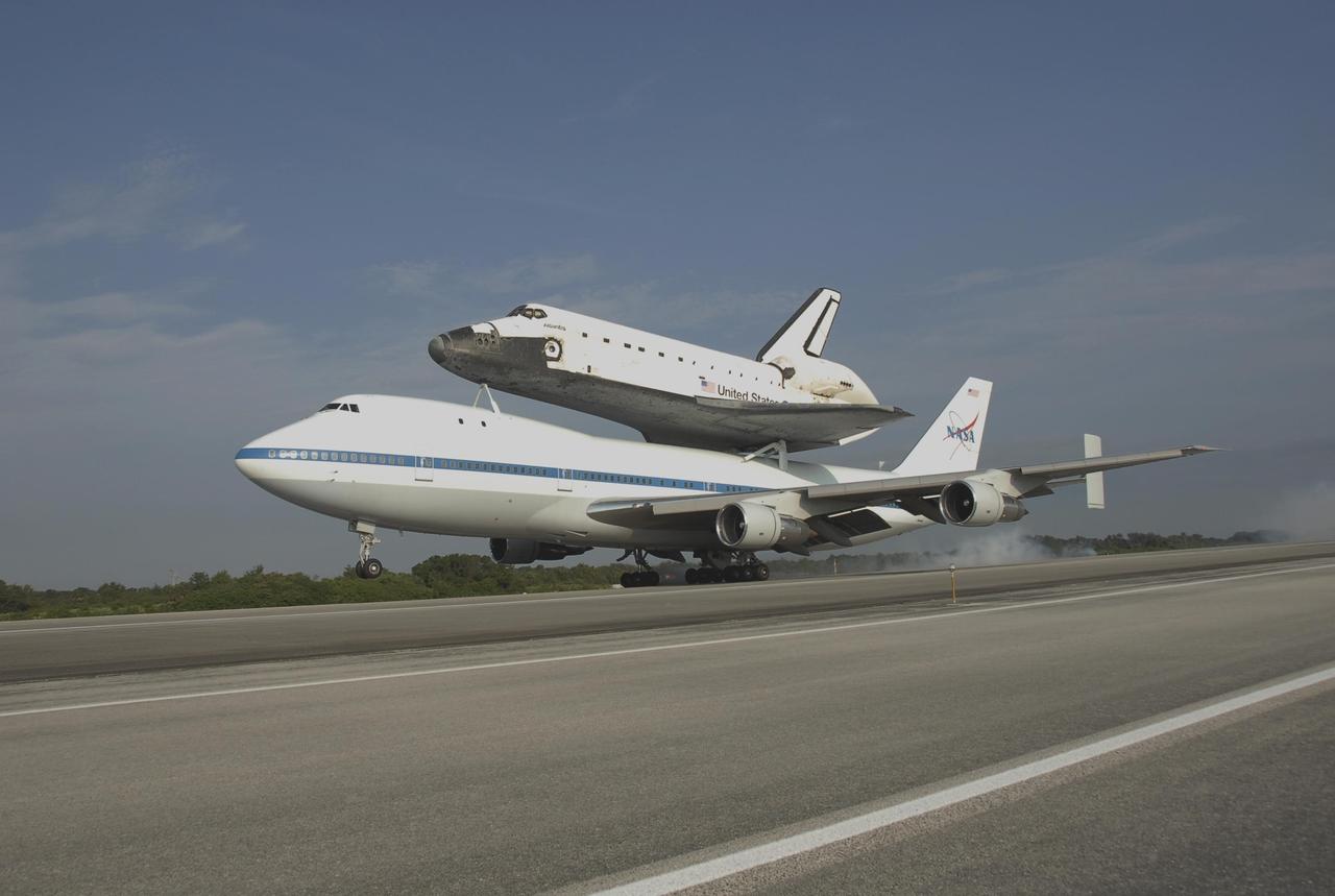 KENNEDY SPACE CENTER, FLA. -- Despite kicking up a little dust, the shuttle carrier aircraft, or SCA, and its piggyback passenger Atlantis make a smooth landing on the KSC Shuttle Landing Facility. Touchdown was at 8:27 a.m. EDT. The SCA is a modified Boeing 747 jetliner. Atlantis landed at Edwards Air Force Base in California to end mission STS-117. The return to KSC began July 1 and took three days after stops across the country for fuel. The last stop was at Ft. Campbell in Kentucky. Weather conditions over the last leg postponed the return trip until July 3. Atlantis will be removed from the back of the SCA via the mate/demate device at the SLF. It will then be towed to the Orbiter Processing Facility to begin processing for its next launch, mission STS-122 in December. Photo credit: NASA/Kim Shiflett