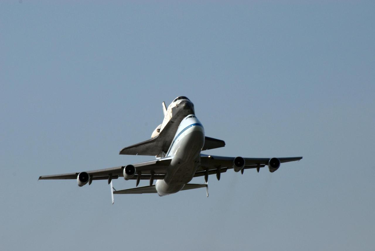 KENNEDY SPACE CENTER, FLA. -- After a three-day trip from California, the shuttle carrier aircraft, or SCA, and its piggyback passenger Atlantis fly around the Kennedy Space Center before landing on the KSC Shuttle Landing Facility runway. Touchdown was at 8:27 a.m. EDT. The SCA is a modified Boeing 747 jetliner. Atlantis landed at Edwards Air Force Base in California to end mission STS-117. The return to KSC began July 1 and took three days after stops across the country for fuel. The last stop was at Ft. Campbell in Kentucky. Weather conditions over the last leg postponed the return trip until July 3. Atlantis will be removed from the back of the SCA via the mate/demate device at the SLF. It will then be towed to the Orbiter Processing Facility to begin processing for its next launch, mission STS-122 in December. Photo credit: NASA/Ken Thornsley