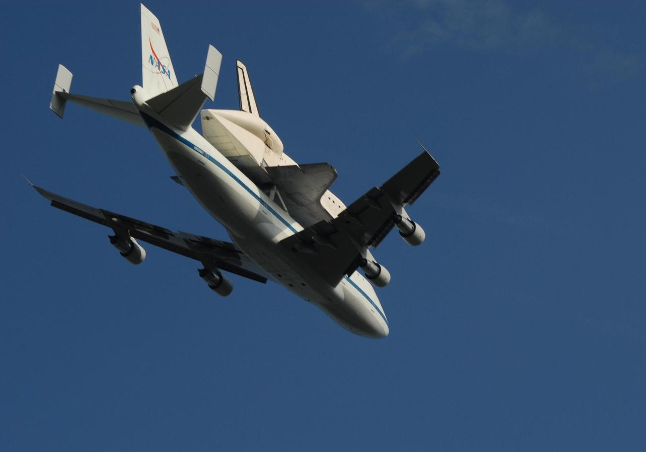 KENNEDY SPACE CENTER, FLA. -- After a three-day trip from California, the shuttle carrier aircraft, or SCA, and its piggyback passenger Atlantis fly over the Kennedy Space Center before landing on the KSC Shuttle Landing Facility runway. Touchdown was at 8:27 a.m. EDT. The SCA is a modified Boeing 747 jetliner. Atlantis landed at Edwards Air Force Base in California to end mission STS-117. The return to KSC began July 1 and took three days after stops across the country for fuel. The last stop was at Ft. Campbell in Kentucky. Weather conditions over the last leg postponed the return trip until July 3. Atlantis will be removed from the back of the SCA via the mate/demate device at the SLF. It will then be towed to the Orbiter Processing Facility to begin processing for its next launch, mission STS-122 in December. Photo credit: NASA/Ken Thornsley