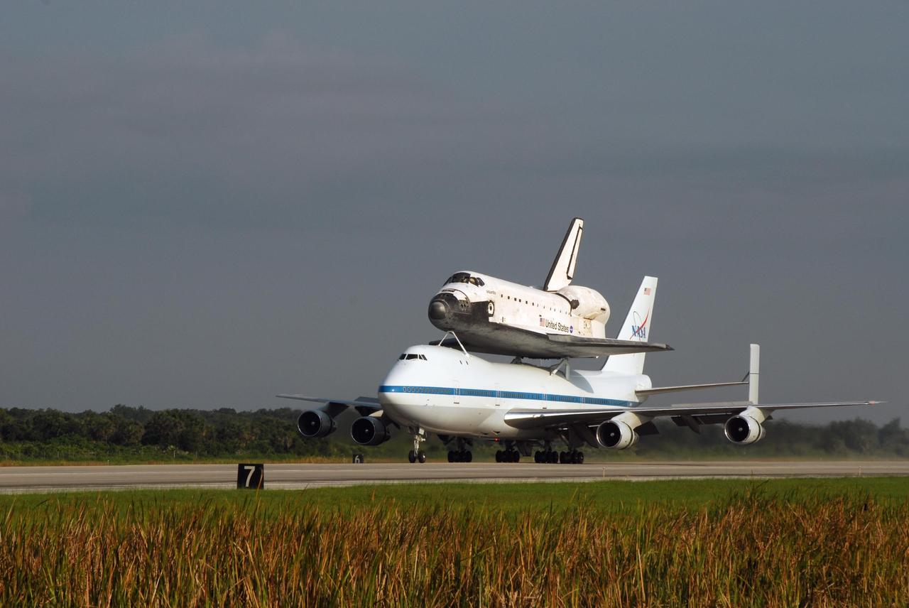 KENNEDY SPACE CENTER, FLA. -- After a three-day trip from California, the shuttle carrier aircraft, or SCA, and its piggyback passenger Atlantis roll down the KSC Shuttle Landing Facility runway. Touchdown was at 8:27 a.m. EDT. The SCA is a modified Boeing 747 jetliner. Atlantis landed at Edwards Air Force Base in California to end mission STS-117. The return to KSC began July 1 and took three days after stops across the country for fuel. The last stop was at Ft. Campbell in Kentucky. Weather conditions over the last leg postponed the return trip until July 3. Atlantis will be removed from the back of the SCA via the mate/demate device at the SLF. It will then be towed to the Orbiter Processing Facility to begin processing for its next launch, mission STS-122 in December. Photo credit: NASA/Ken Thornsley