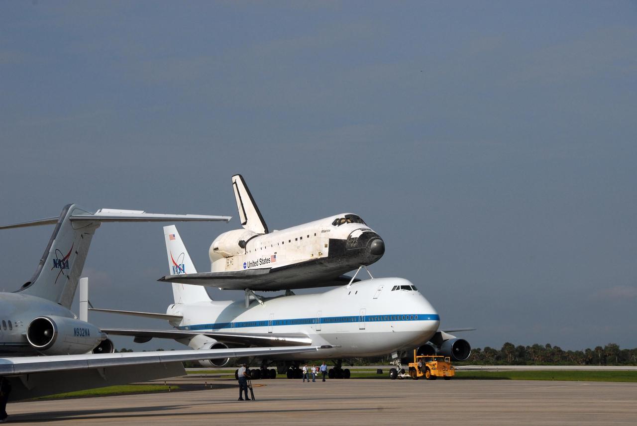 KENNEDY SPACE CENTER, FLA. -- After a three-day trip from California, the shuttle carrier aircraft, or SCA, and its piggyback passenger Atlantis are parked on the KSC Shuttle Landing Facility. Touchdown was at 8:27 a.m. EDT. The SCA is a modified Boeing 747 jetliner. Visible on Atlantis is the tail cone that covers and protects the main engines during the ferry flight. Atlantis landed at Edwards Air Force Base in California to end mission STS-117. The return to KSC began July 1 and took three days after stops across the country for fuel. The last stop was at Ft. Campbell in Kentucky. Weather conditions over the last leg postponed the return trip until July 3. Atlantis will be removed from the back of the SCA via the mate/demate device at the SLF. It will then be towed to the Orbiter Processing Facility to begin processing for its next launch, mission STS-122 in December. Photo credit: NASA/Ken Thornsley