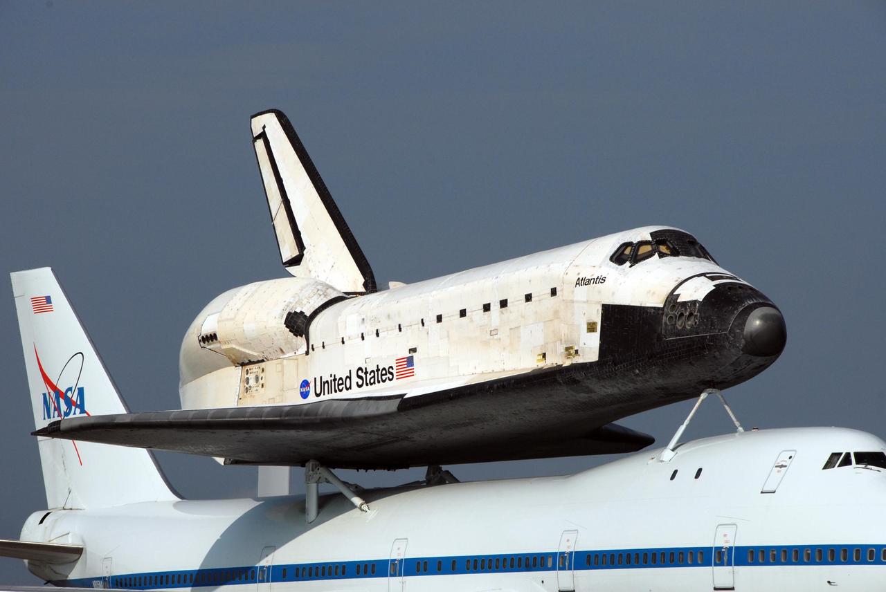 KENNEDY SPACE CENTER, FLA. --  Struts on the shuttle carrier aircraft, or SCA, attach the orbiter Atlantis for the piggyback flight.  The plane and orbiter returned from California after three days.  Touchdown was at 8:27 a.m. EDT. The SCA is a modified Boeing 747 jetliner. Visible on Atlantis is the tail cone that covers and protects the main engines during the ferry flight.  Atlantis landed at Edwards Air Force Base in California to end mission STS-117.  The return to KSC began July 1 and  took three days after stops across the country for fuel.  The last stop was at Ft. Campbell in Kentucky. Weather conditions over the last leg postponed the return trip until July 3.  Atlantis will be removed from the back of the SCA via the mate/demate device at the SLF.  It will then be towed to the Orbiter Processing Facility to begin processing for its next launch, mission STS-122 in December.  Photo credit: NASA/Ken Thornsley