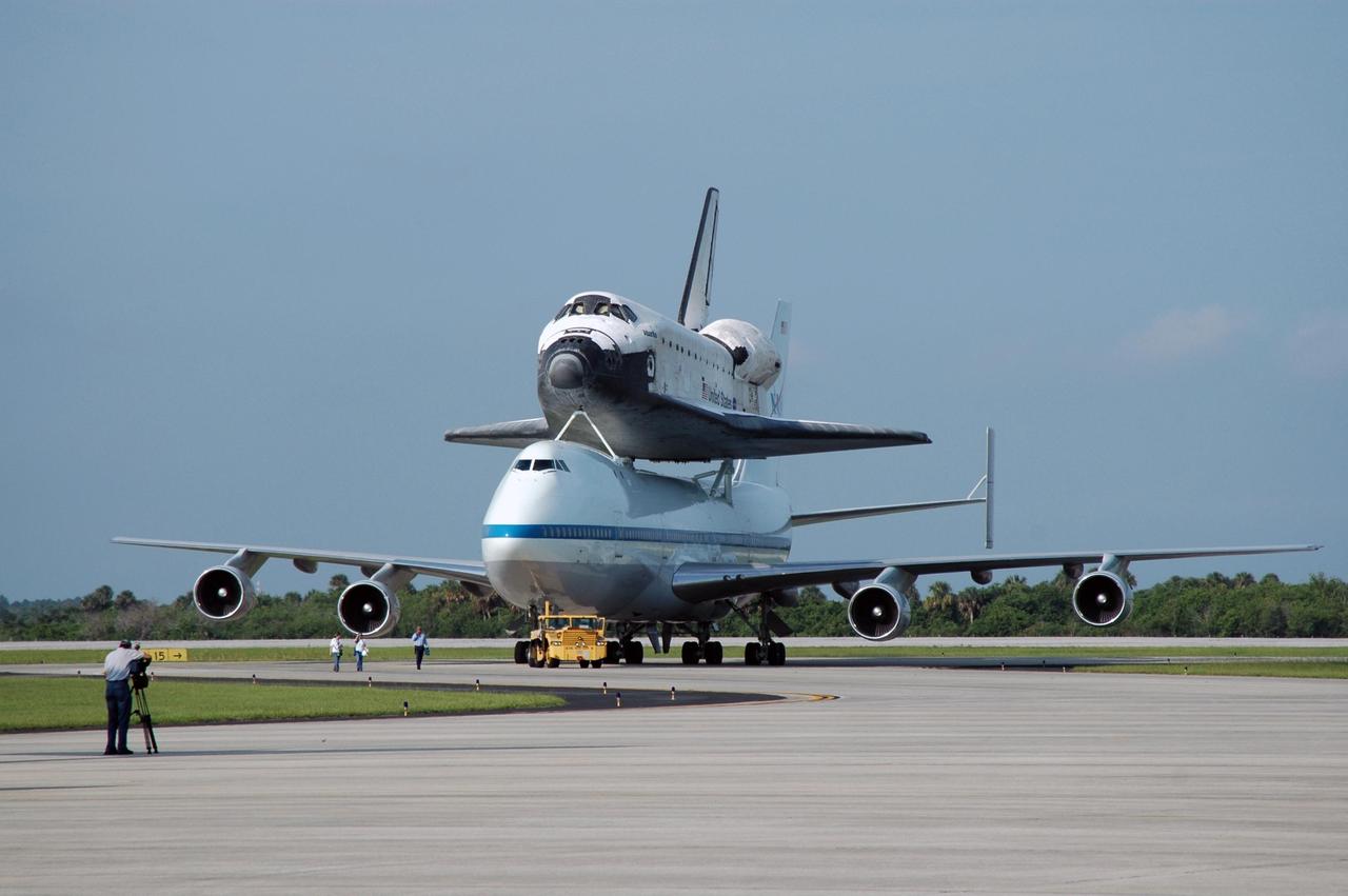 KENNEDY SPACE CENTER, FLA. -- After landing at the KSC Shuttle Landing Facility, the shuttle carrier aircraft, or SCA, and its piggyback passenger Atlantis are towed from the runway. Touchdown was at 8:27 a.m. EDT. The SCA is a modified Boeing 747 jetliner. Atlantis landed at Edwards Air Force Base in California to end mission STS-117. The return to KSC began July 1 and took three days after stops across the country for fuel. The last stop was at Ft. Campbell in Kentucky. Weather conditions over the last leg postponed the return trip until July 3. Atlantis will be removed from the back of the SCA via the mate/demate device at the SLF. It will then be towed to the Orbiter Processing Facility to begin processing for its next launch, mission STS-122 in December. Photo credit: NASA/Jim Grossmann