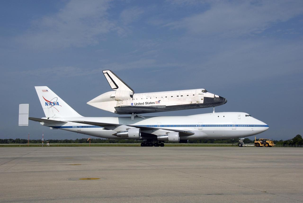 KENNEDY SPACE CENTER, FLA. -- After landing at the KSC Shuttle Landing Facility, the shuttle carrier aircraft, or SCA, and its piggyback passenger Atlantis are towed from the runway. Touchdown was at 8:27 a.m. EDT. The SCA is a modified Boeing 747 jetliner. Visible on Atlantis is the tail cone that covers and protects the main engines during the ferry flight. Atlantis landed at Edwards Air Force Base in California to end mission STS-117. The return to KSC began July 1 and included several stops across the country for fuel. The last stop was at Ft. Campbell in Kentucky. Weather conditions over the last leg postponed the return trip until July 3. Atlantis will be removed from the back of the SCA via the mate/demate device at the SLF. It will then be towed to the Orbiter Processing Facility to begin processing for its next launch, mission STS-122 in December. Photo credit: NASA/Kim Shiflett
