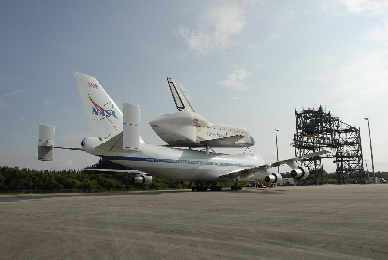 KENNEDY SPACE CENTER, FLA. --   After landing at the KSC Shuttle Landing Facility, the shuttle carrier aircraft, or SCA, and its piggyback passenger Atlantis are towed toward the mate/demate device that will put the orbiter back on the ground.  After a three-day, cross-country trip, the duo touched down at 8:27 a.m. EDT. The SCA is a modified Boeing 747 jetliner. Visible on Atlantis is the tail cone that covers and protects the main engines during the ferry flight. Atlantis landed at Edwards Air Force Base in California to end mission STS-117.  The return to KSC began July 1 and included several stops across the country for fuel.  The last stop was at Ft. Campbell in Kentucky. Weather conditions over the last leg postponed the return trip until July 3.  After demate, Atlantis will then be towed to the Orbiter Processing Facility to begin processing for its next launch, mission STS-122 in December.  Photo credit: NASA/Kim Shiflett