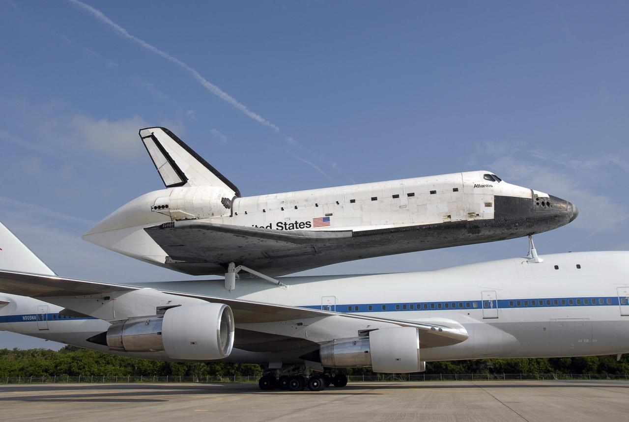 KENNEDY SPACE CENTER, FLA. -- After landing at the KSC Shuttle Landing Facility, the shuttle carrier aircraft, or SCA, and its piggyback passenger Atlantis are towed to the mate/demate device that will put the orbiter back on the ground. After a three-day, cross-country trip, the duo touched down at 8:27 a.m. EDT. The SCA is a modified Boeing 747 jetliner. Visible on Atlantis is the tail cone that covers and protects the main engines during the ferry flight. Atlantis landed at Edwards Air Force Base in California to end mission STS-117. The return to KSC began July 1 and included several stops across the country for fuel. The last stop was at Ft. Campbell in Kentucky. Weather conditions over the last leg postponed the return trip until July 3. After demate, Atlantis will then be towed to the Orbiter Processing Facility to begin processing for its next launch, mission STS-122 in December. Photo credit: NASA/Kim Shiflett