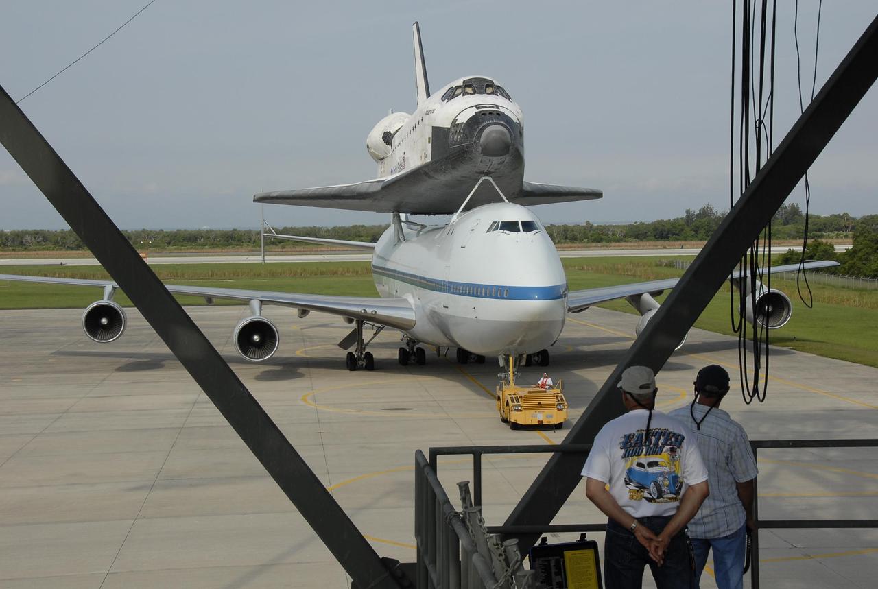 KENNEDY SPACE CENTER, FLA. --  On the KSC Shuttle Landing Facility, the shuttle carrier aircraft, or SCA, with the orbiter Atlantis on its back is towed toward the mate/demate device.  Under the device, the orbiter will be detached from the SCA and lowered onto a transporter.  Then Atlantis will be towed to the Orbiter Processing Facility to begin processing for its next launch, mission STS-122 in December.  Atlantis landed at Edwards Air Force Base in California on June 22 to end mission STS-117.  It returned to Kennedy atop the SCA on July 3 after a three-day, cross-country flight due to fuel stops and weather delays. Touchdown was at 8:27 a.m. EDT. Photo credit: NASA/Kim Shiflett