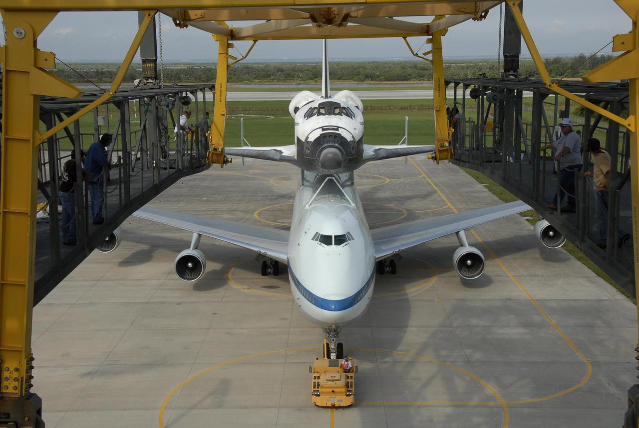 KENNEDY SPACE CENTER, FLA. --  On the KSC Shuttle Landing Facility, the shuttle carrier aircraft, or SCA, with the orbiter Atlantis on its back is towed under the mate/demate device.  The orbiter will be detached from the SCA and lowered onto a transporter.  Then Atlantis will be towed to the Orbiter Processing Facility to begin processing for its next launch, mission STS-122 in December. Atlantis landed at Edwards Air Force Base in California on June 22 to end mission STS-117.  It returned to Kennedy atop the SCA on July 3 after a three-day, cross-country flight due to fuel stops and weather delays. Touchdown was at 8:27 a.m. EDT. Photo credit: NASA/Kim Shiflett