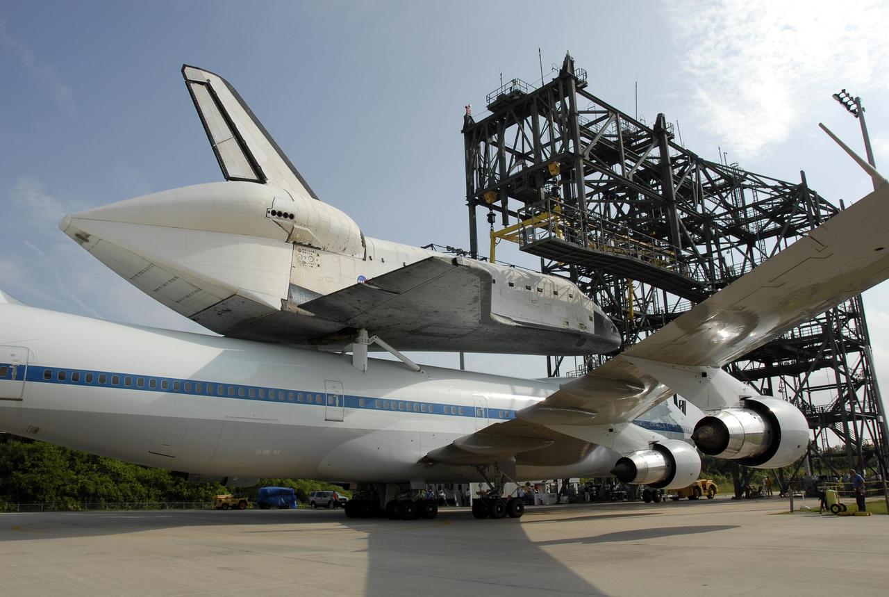 KENNEDY SPACE CENTER, FLA. --  On the KSC Shuttle Landing Facility, the shuttle carrier aircraft, or SCA, with the orbiter Atlantis on its back is towed toward the mate/demate device (background).  Visible on Atlantis is the tail cone that covers and protects the main engines during the ferry flight. Under the device, the orbiter will be detached from the SCA and lowered onto a transporter.  Then Atlantis will be towed to the Orbiter Processing Facility to begin processing for its next launch, mission STS-122 in December. Atlantis landed at Edwards Air Force Base in California on June 22 to end mission STS-117.  It returned to Kennedy atop the SCA on July 3 after a three-day, cross-country flight due to fuel stops and weather delays. Touchdown was at 8:27 a.m. EDT. Photo credit: NASA/Kim Shiflett