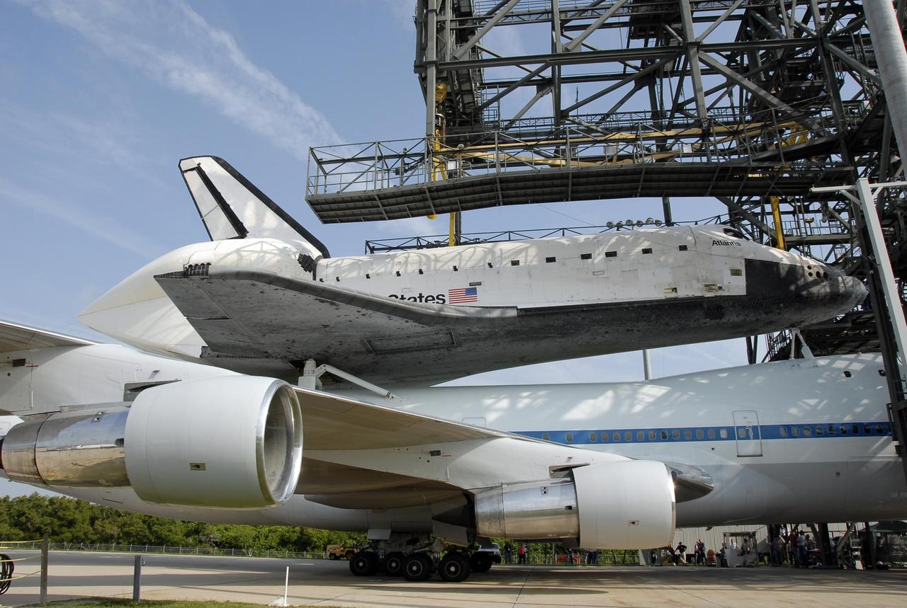 KENNEDY SPACE CENTER, FLA. --  On the KSC Shuttle Landing Facility, the shuttle carrier aircraft, or SCA, with the orbiter Atlantis on its back is towed under the mate/demate device.  Visible on Atlantis is the tail cone that covers and protects the main engines during the ferry flight. The orbiter will be detached from the SCA and lowered onto a transporter.  Then Atlantis will be towed to the Orbiter Processing Facility to begin processing for its next launch, mission STS-122 in December.  Atlantis landed at Edwards Air Force Base in California on June 22 to end mission STS-117.  It returned to Kennedy atop the SCA on July 3 after a three-day, cross-country flight due to fuel stops and weather delays. Touchdown was at 8:27 a.m. EDT. Photo credit: NASA/Kim Shiflett