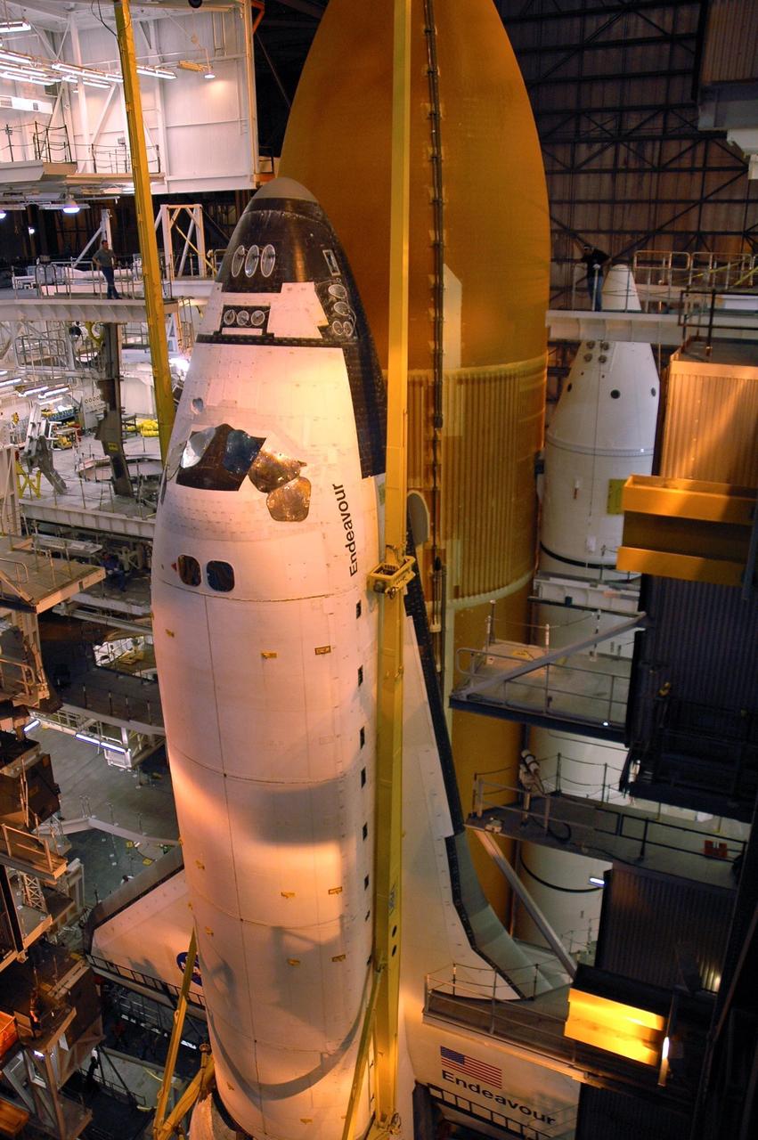 KENNEDY SPACE CENTER, FLA. --  In high bay 1 of the Vehicle Assembly Building, the orbiter Endeavour is lowered past the external tank toward the mobile launcher platform.  Seen at right of the external tank is one of the white solid rocket boosters. The components will be mated for launch.  Endeavour will be launched on mission STS-118, its first flight in more than four years. The shuttle has undergone extensive modifications, including the addition of safety upgrades already added to shuttles Discovery and Atlantis. Endeavour also features new hardware, such as the Station-to-Shuttle Power Transfer System that will allow the docked shuttle to draw electrical power from the station and extend its visits to the orbiting lab.  Endeavour is targeted for launch on Aug. 7.     Photo credit: NASA/Troy Cryder