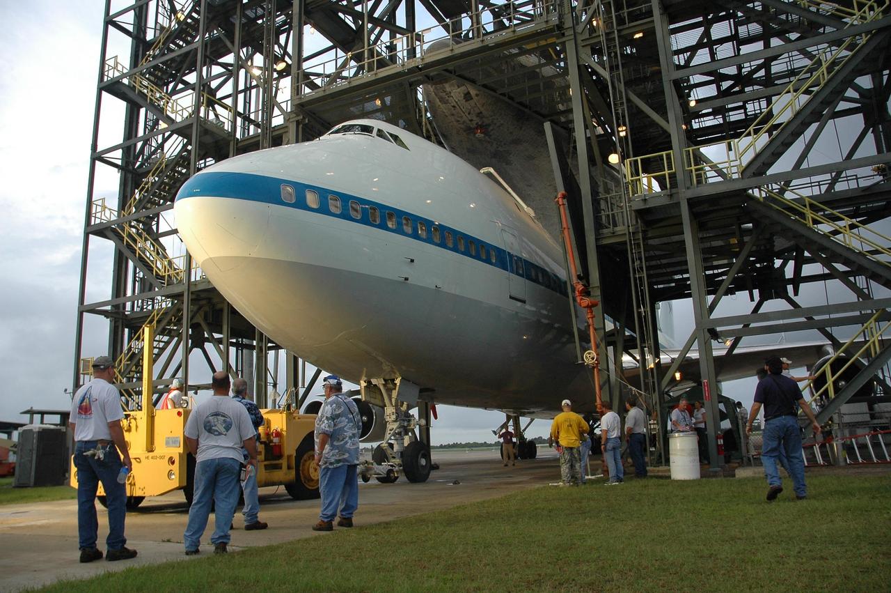 KENNEDY SPACE CENTER, FLA. -- At the mate/demate device at Kennedy Space Center's Shuttle Landing Facility, workers monitor the progress as Atlantis is lifted up from the shuttle carrier aircraft, or SCA. The orbiter will be lowered onto the ground and then towed to the Orbiter Processing Facility to begin processing for its next launch, mission STS-122 in December. Atlantis arrived at Kennedy Space Center atop the SCA on July 3 after a three-day, cross-country flight due to fuel stops and weather delays. Touchdown was at 8:27 a.m. EDT. Atlantis landed at Edwards Air Force Base in California on June 22 to end mission STS-117. Photo credit: NASA/Jack Pfaller.