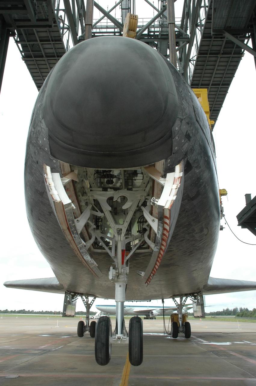 KENNEDY SPACE CENTER, FLA. --  Atlantis is lowered to the ground at the mate/demate device at Kennedy Space Center's Shuttle Landing Facility. In the background the shuttle carrier aircraft, or SCA, can be seen. The orbiter will be detached from the lifting crane and then towed to the Orbiter Processing Facility to begin processing for its next launch, mission STS-122 in December. Atlantis arrived at Kennedy Space Center atop the SCA on July 3 after a three-day, cross-country flight due to fuel stops and weather delays. Touchdown was at 8:27 a.m. EDT. Atlantis landed at Edwards Air Force Base in California on June 22 to end mission STS-117.  Photo credit: NASA/Jack Pfaller.
