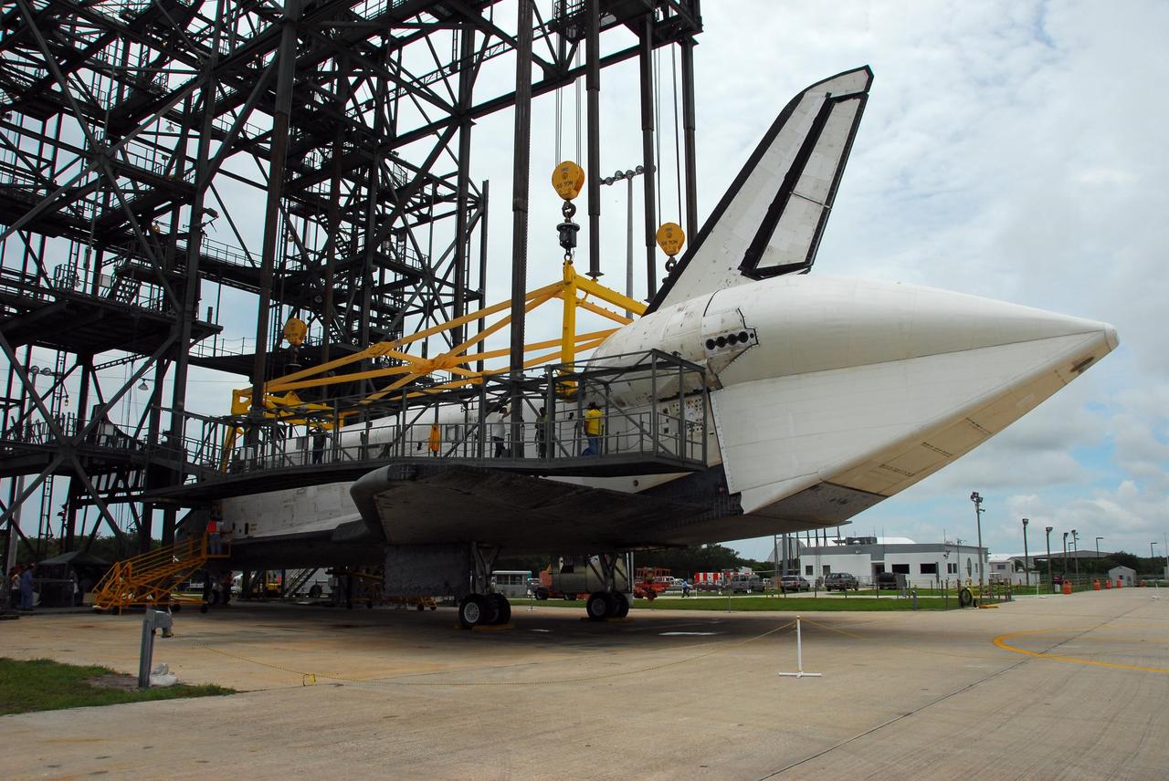KENNEDY SPACE CENTER, FLA. --  At the mate/demate device at Kennedy Space Center's Shuttle Landing Facility, technicians begin the process of detaching the lifting crane from Atlantis. Visible on Atlantis is the tail cone that covers and protects the main engines during the ferry flight. The orbiter will be towed to the Orbiter Processing Facility to begin processing for its next launch, mission STS-122 in December. Atlantis arrived at Kennedy Space Center atop the shuttle carrier aircraft, or SCA, on July 3 after a three-day, cross-country flight due to fuel stops and weather delays. Touchdown was at 8:27 a.m. EDT. Atlantis landed at Edwards Air Force Base in California on June 22 to end mission STS-117.  Photo credit: NASA/George Shelton.