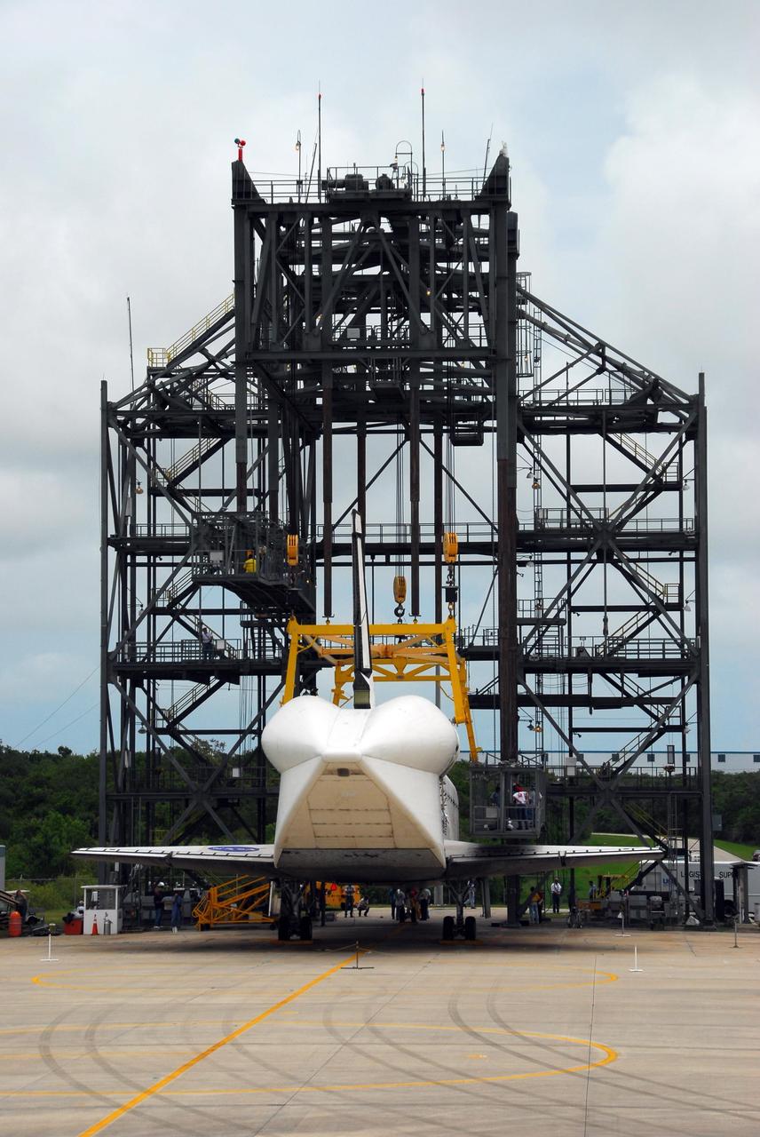 KENNEDY SPACE CENTER, FLA. --  At the mate/demate device at Kennedy Space Center's Shuttle Landing Facility, Atlantis is detached from the lifting crane and workers prepare the orbiter for towing to the Orbiter Processing Facility where processing will begin for its next launch, mission STS-122 in December. Visible on Atlantis is the tail cone that covers and protects the main engines during the ferry flight. Atlantis arrived at Kennedy Space Center atop the shuttle carrier aircraft, or SCA, on July 3 after a three-day, cross-country flight due to fuel stops and weather delays. Touchdown was at 8:27 a.m. EDT. Atlantis landed at Edwards Air Force Base in California on June 22 to end mission STS-117.  Photo credit: NASA/George Shelton.