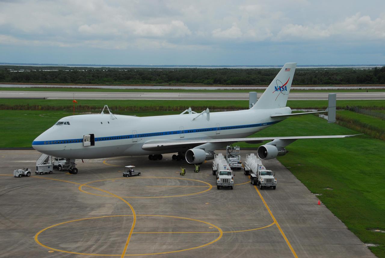 KENNEDY SPACE CENTER, FLA. -- The shuttle carrier aircraft, or SCA, sits on the tarmac at Kennedy Space Center's Shuttle Landing Facility after demate from Atlantis. Several service vehicles have arrived to prepare the aircraft for its flight back to Johnson Space Center in Texas. Atlantis arrived at Kennedy Space Center atop the SCA on July 3 after a three-day, cross-country flight due to fuel stops and weather delays. Touchdown was at 8:27 a.m. EDT. Atlantis landed at Edwards Air Force Base in California on June 22 to end mission STS-117. Photo credit: NASA/George Shelton.