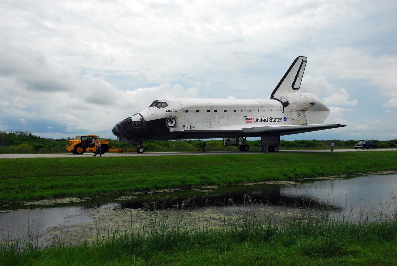 KENNEDY SPACE CENTER, FLA. -- After demate from the shuttle carrier aircraft, or SCA, Atlantis begins its trek from Kennedy Space Center's Shuttle Landing Facility to the Orbiter Processing Facility. The orbiter will undergo processing for its next launch, mission STS-122 in December. Visible on Atlantis is the tail cone that covers and protects the main engines during the ferry flight. Atlantis arrived at Kennedy Space Center atop the SCA on July 3 after a three-day, cross-country flight due to fuel stops and weather delays. Touchdown was at 8:27 a.m. EDT. Atlantis landed at Edwards Air Force Base in California on June 22 to end mission STS-117. Photo credit: NASA/George Shelton.