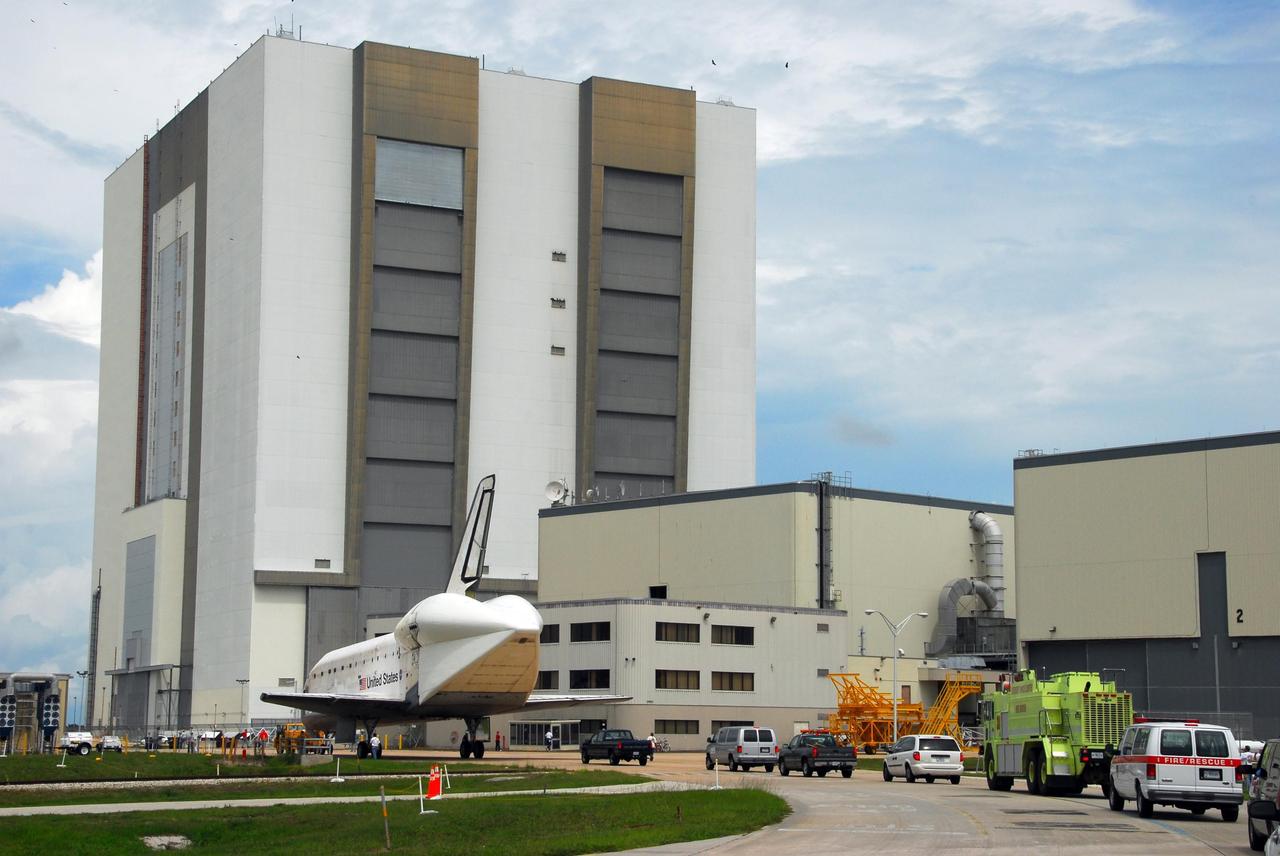 KENNEDY SPACE CENTER, FLA. -- Atlantis is towed toward the Orbiter Processing Facility from the Shuttle Landing Facility at Kennedy Space Center. The orbiter will undergo processing for its next launch, mission STS-122 in December. Visible on Atlantis is the tail cone that covers and protects the main engines during the ferry flight. The massive Vehicle Assembly Building towers in the background. Atlantis arrived at Kennedy Space Center atop the SCA on July 3 after a three-day, cross-country flight due to fuel stops and weather delays. Touchdown was at 8:27 a.m. EDT. Atlantis landed at Edwards Air Force Base in California on June 22 to end mission STS-117. Photo credit: NASA/George Shelton.
