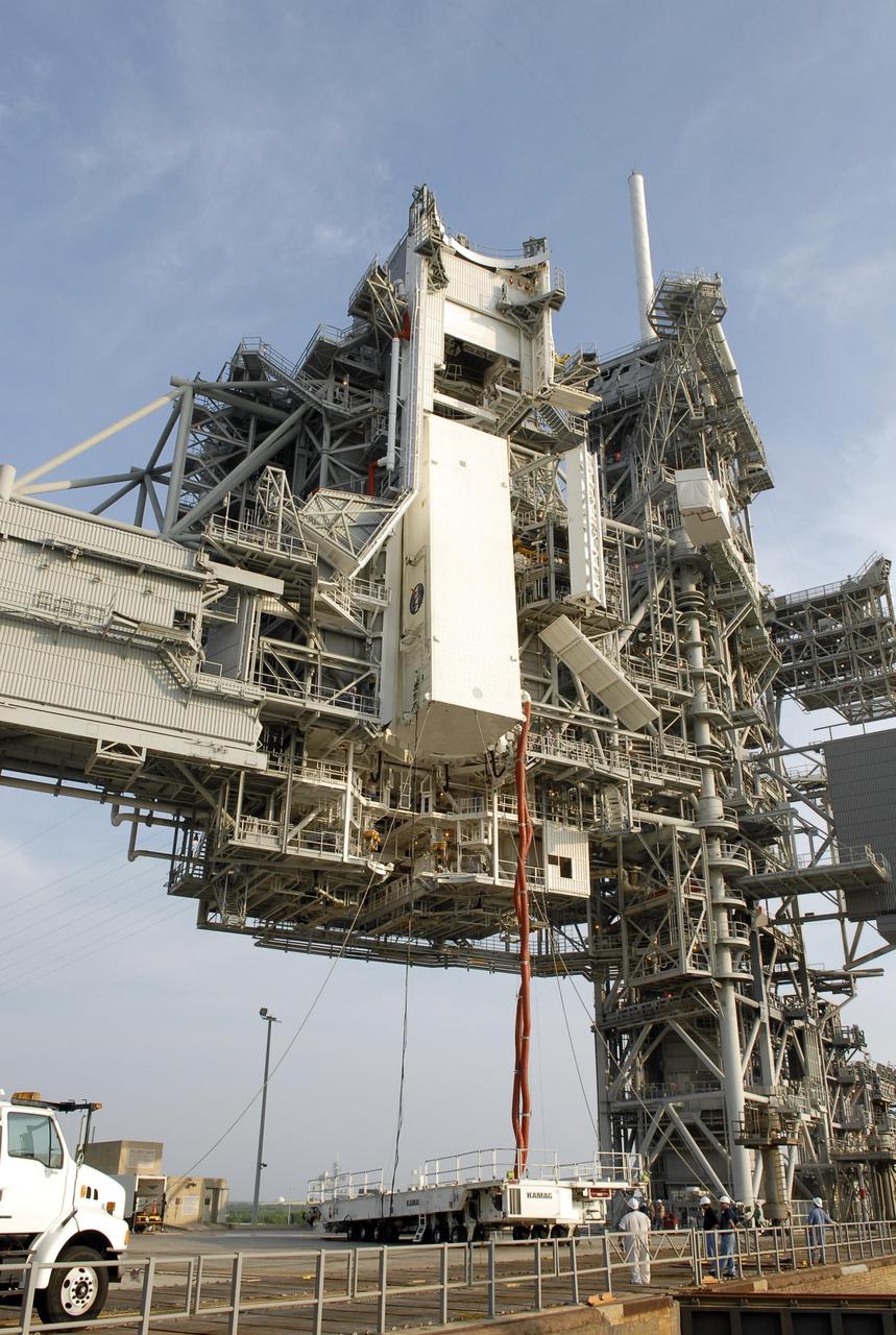 KENNEDY SPACE CENTER, FLA. -- With umbilical lines still attached, the payload canister arrives at the payload changeout room. Inside the canister are the S5 truss, SPACEHAB module and external stowage platform 3, the payload for mission STS-118. The payloads will be transferred inside the changeout room to wait for Space Shuttle Endeavour to arrive at the pad. The changeout room is the enclosed, environmentally controlled portion of the rotating service structure that supports cargo delivery to the pad and subsequent vertical installation into the orbiter payload bay. The mission will be Endeavour's first flight in more than four years. The shuttle has undergone extensive modifications, including the addition of safety upgrades already added to shuttles Discovery and Atlantis. Endeavour also features new hardware, such as the Station-to-Shuttle Power Transfer System that will allow the docked shuttle to draw electrical power from the station and extend its visits to the orbiting lab. Space Shuttle Endeavour is targeted for launch on Aug. 7 from Launch Pad 39A. Photo credit: NASA/Kim Shiflett