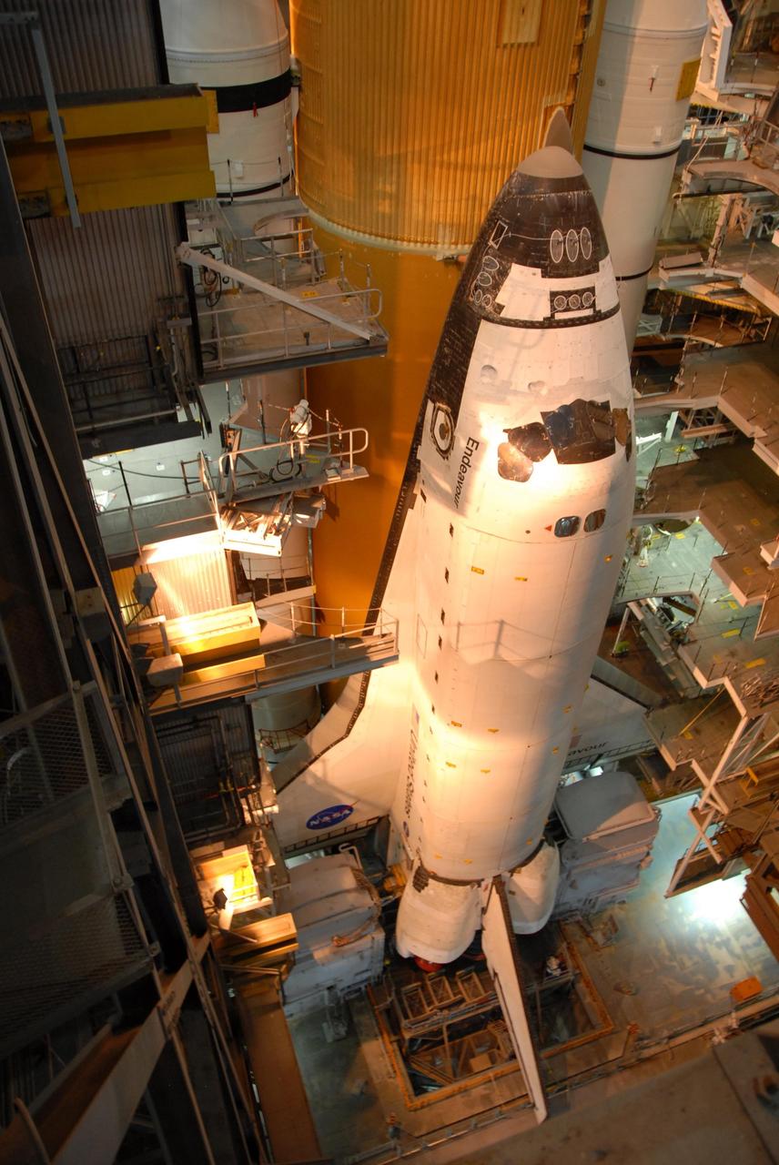 KENNEDY SPACE CENTER, FLA. --   Space Shuttle Endeavour is viewed from a high level in the Vehicle Assembly Building.  Lights from above cast an orange glow.  Visible behind Endeavour are the orange external tank and the white solid rocket boosters on either side.  The many platform levels on either side of the shuttle provide access for work.  The shuttle assembly rests on the mobile launcher platform, which will be lifted by the crawler-transporter for the slow journey to the pad.  Rollout was originally planned for just after midnight on July 10 but the move was canceled by NASA managers because unfavorable weather was predicted to arrive in the launch area before the vehicle would be secured at the pad.   Rollout is scheduled to begin again about 9 p.m. July 10.  Photo credit: NASA/Ken Thornsley