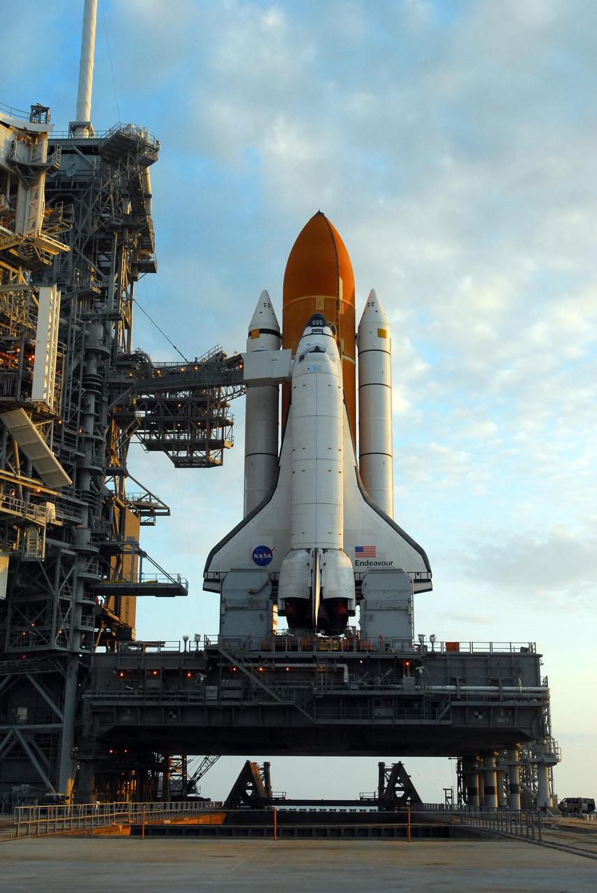 KENNEDY SPACE CENTER, FLA. -- Space Shuttle Endeavour is on Launch Pad 39A and ready for prelaunch processing after a nearly 7-hour trip from the Vehicle Assembly Building. First motion out of the VAB was at 8:10 p.m. July 10, and the shuttle was hard down on the pad at 3:02 a.m. July 11. The orbiter access arm is already extended to the orbiter from the fixed service structure at left. On top of the structure is the 80-foot-tall lightning mast that helps provide protection from lightning on the pad. The shuttle sits on a mobile launcher platform. Part of the platform and seen below the orbiter's wings are the tail masts, which provide several umbilical connections to the orbiter, including a liquid-oxygen line through one and a liquid-hydrogen line through another. Endeavour is scheduled to launch on mission STS-118 on Aug. 7. During the mission, Endeavour will carry into orbit the S5 truss, SPACEHAB module and external stowage platform 3. The mission is the 22nd flight to the International Space Station and will mark the first flight of Mission Specialist Barbara Morgan, the teacher-turned-astronaut whose association with NASA began more than 20 years ago. STS-118 will be the first flight since 2002 for Endeavour, which has undergone extensive modifications, including the addition of safety upgrades already added to orbiters Discovery and Atlantis. Photo credit: NASA/George Shelton