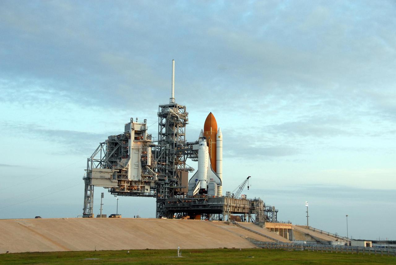 KENNEDY SPACE CENTER, FLA. - Space Shuttle Endeavour is on Launch Pad 39A and ready for prelaunch processing after a nearly 7-hour trip from the Vehicle Assembly Building. First motion out of the VAB was at 8:10 p.m. July 10, and the shuttle was hard down on the pad at 3:02 a.m. July 11. At far left is the rotating service structure, called the RSS, which can be rolled around to enclose the shuttle for access during processing. Between the RSS and the shuttle is the fixed service structure, topped by an 80-foot-tall lightning mast. Endeavour is scheduled to launch on mission STS-118 on Aug. 7. During the mission, Endeavour will carry into orbit the S5 truss, SPACEHAB module and external stowage platform 3. The mission is the 22nd flight to the International Space Station and will mark the first flight of Mission Specialist Barbara Morgan, the teacher-turned-astronaut whose association with NASA began more than 20 years ago. STS-118 will be the first flight since 2002 for Endeavour, which has undergone extensive modifications, including the addition of safety upgrades already added to orbiters Discovery and Atlantis. Photo credit: NASA/Ken Thornsley