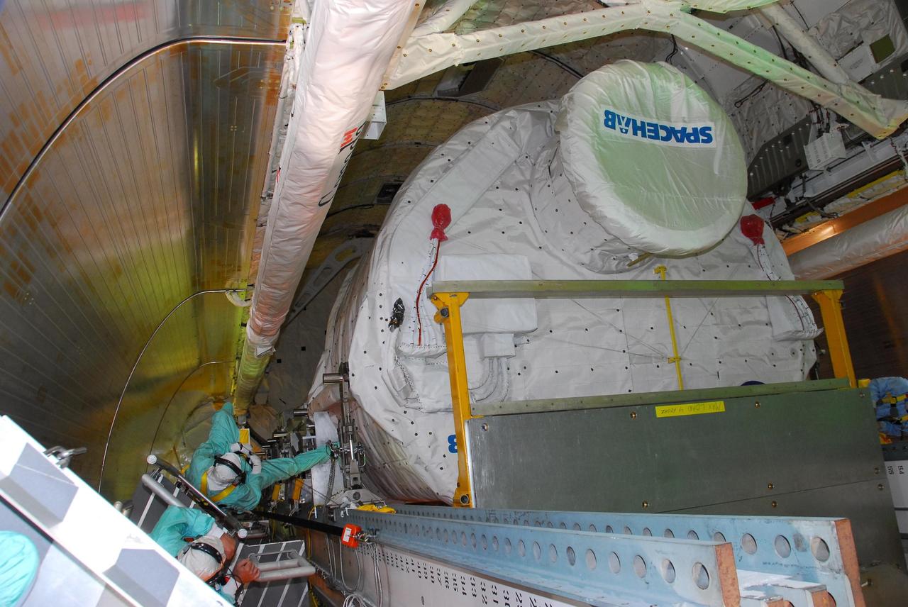 KENNEDY SPACE CENTER, FLA. -- On Launch Pad 39A, workers help transfer the payload for mission STS-118 from the payload changeout room into the payload bay on Space Shuttle Endeavour. Seen here is the SPACEHAB module. The payload also includes the S5 truss and external stowage platform 3. The mission is the 22nd flight to the International Space Station and is targeted for launch on Aug.7. Photo credit: NASA/Amanda Diller