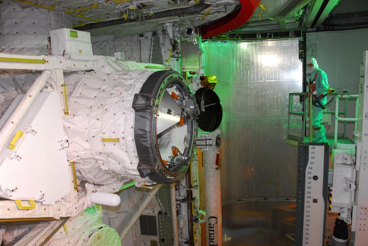 KENNEDY SPACE CENTER, FLA. -- On Launch Pad 39A, a worker helps transfer the payload for mission STS-118 from the payload changeout room into the payload bay on Space Shuttle Endeavour. Seen here is the orbiter docking system. The payload also includes the S5 truss, the SPACEHAB module and external stowage platform 3. The mission is the 22nd flight to the International Space Station and is targeted for launch on Aug.7. Photo credit: NASA/Amanda Diller