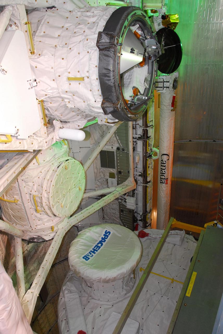 KENNEDY SPACE CENTER, FLA. -- The payload for mission STS-118 is being installed in the payload bay on Space Shuttle Endeavour on Launch Pad 39A. Seen here, from top, are the orbiter docking system, the SPACEHAB tunnel adapter and the SPACEHAB module. The payload also includes the S5 truss and the external stowage platform 3. The mission is the 22nd flight to the International Space Station and is targeted for launch on Aug.7. Photo credit: NASA/Amanda Diller