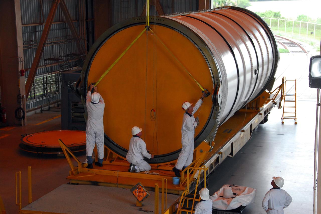KENNEDY SPACE CENTER, FLA. --  In the Rotation, Processing and Surge Facility, or RSPF, workers begin to remove the cover on a solid rocket booster segment for propellant grain inspection required as part of safety analysis.  The booster segment will be stacked with others to be used on Space Shuttle Atlantis on mission STS-122 targeted for December. The mission will continue assembly of the International Space Station, delivering and installing the Columbus Laboratory.  Photo credit: NASA/George Shelton