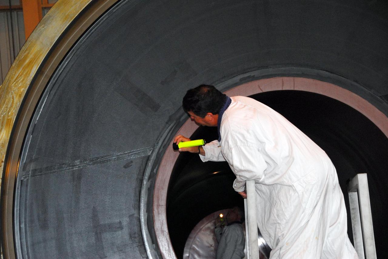 KENNEDY SPACE CENTER, FLA. -- In the Rotation, Processing and Surge Facility, or RSPF, a worker conducts propellant grain inspection of the solid rocket booster segment required as part of safety analysis. The booster segment will be stacked with others to be used on Space Shuttle Atlantis on mission STS-122 targeted for December. The mission will continue assembly of the International Space Station, delivering and installing the Columbus Laboratory.  Photo credit: NASA/George Shelton