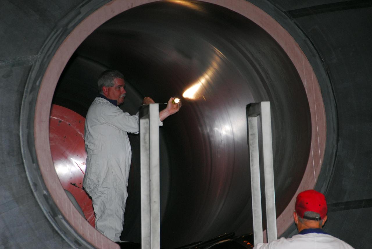 KENNEDY SPACE CENTER, FLA. -- In the Rotation, Processing and Surge Facility, or RSPF, a worker conducts propellant grain inspection of the solid rocket booster segment required as part of safety analysis. The booster segment will be stacked with others to be used on Space Shuttle Atlantis on mission STS-122 targeted for December. The mission will continue assembly of the International Space Station, delivering and installing the Columbus Laboratory.  Photo credit: NASA/George Shelton