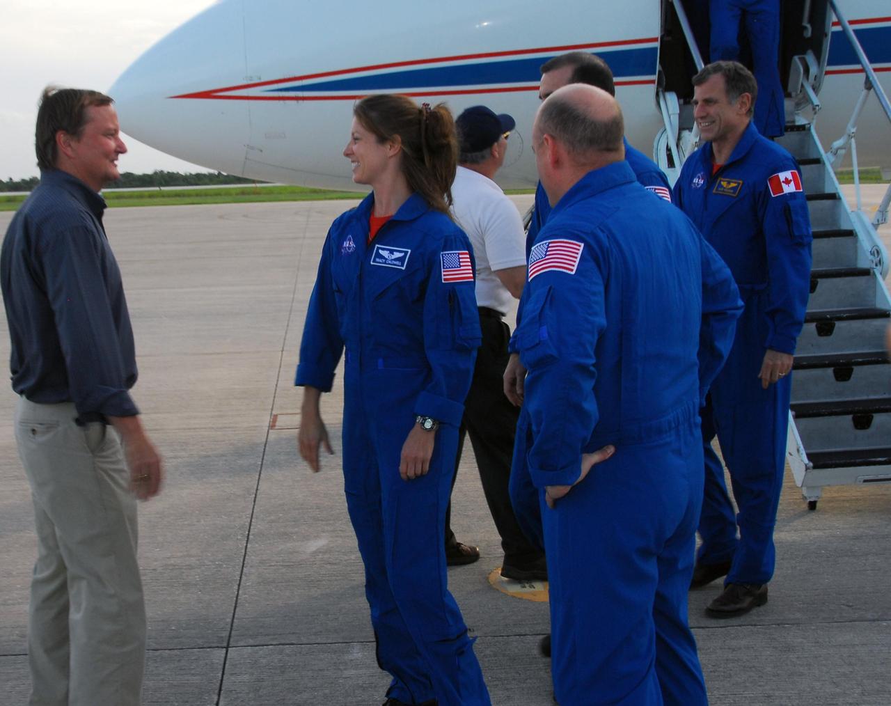 KENNEDY SPACE CENTER, Fla.  -- The STS-118 crew arrives at Kennedy's Shuttle Landing Facility aboard a Shuttle Training Aircraft to take part in the Terminal Countdown Demonstration Test (TCDT), a dress rehearsal for launch. Shuttle Launch Director Mike Leinbach (left) welcomes Mission Specialists Tracy Caldwell, Rick Mastracchio and Dave Williams of the Canadian Space Agency, as Commander Scott Kelly (back to camera) looks on. TCDT activities include M-113 armored personnel carrier training, payload familiarization, emergency egress training at the pad and a simulated launch countdown. The STS-118 payload aboard Space Shuttle Endeavour includes the S5 truss, a SPACEHAB module and external stowage platform 3. The mission is the 22nd flight to the International Space Station and is targeted for launch on Aug.7. Photo credit: NASA/George Shelton