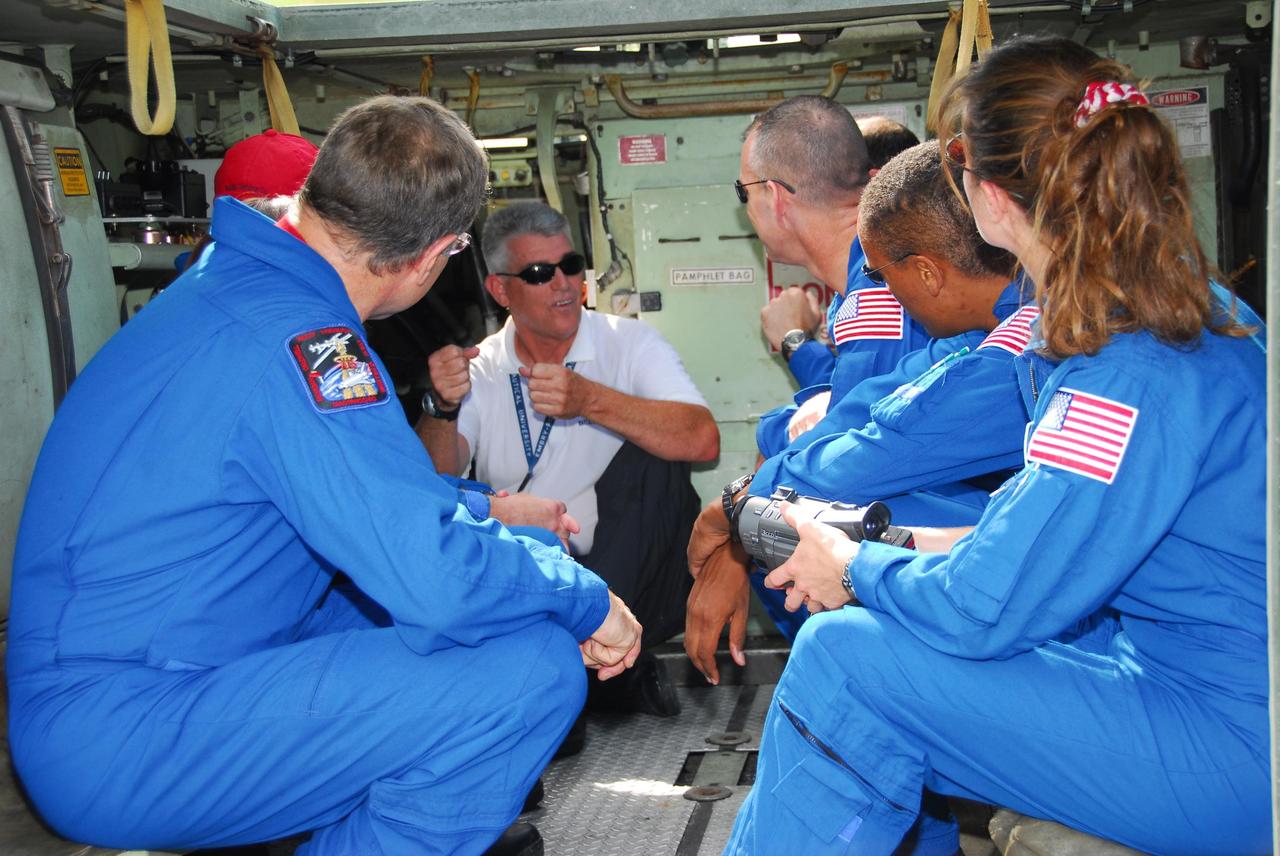 KENNEDY SPACE CENTER, Fla.  --  Inside an M-113 armored personnel carrier, the STS-118 crew gets instructions on its use for emergency exit procedures from Launch Pad 39A.  At left is Mission Specialist Dave Williams, who represents the Canadian Space Agency.  At right are (back to front) Pilot Charlie Hobaugh and Mission Specialists Alvin Drew and Tracy Caldwell.  TCDT activities include the M-113 training, payload familiarization, emergency egress training at the pad and a simulated launch countdown.  The STS-118 payload aboard Space Shuttle Endeavour includes the S5 truss, a SPACEHAB module and external stowage platform 3. The mission is the 22nd flight to the International Space Station and is targeted for launch on Aug.7.  NASA/George Shelton