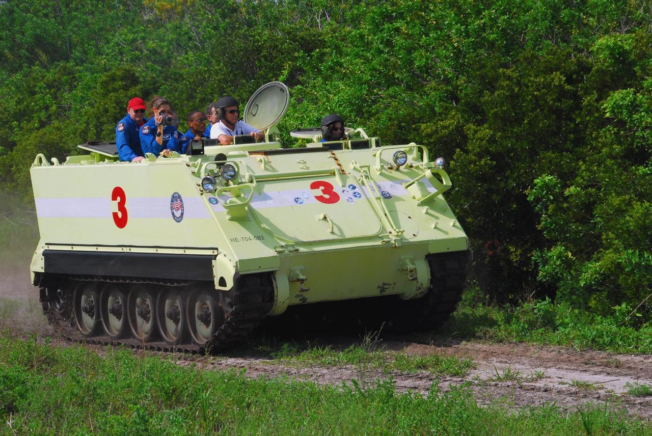 KENNEDY SPACE CENTER, Fla.  --  STS-118 Mission Specialist  Barbara R. Morgan practices driving an M-113 armored personnel carrier as part of emergency exit training.  Seen in the back, at left, are Commander Scott Kelly and Mission Specialists Tracy Caldwell and Alvin Drew.  Morgan joined NASA's Teacher in Space program in 1985 and was selected as an astronaut in 1998. She and other crew members are at Kennedy for the Terminal Countdown Demonstration Test (TCDT), a dress rehearsal for launch. TCDT activities include the M-113 training, payload familiarization, emergency egress training at the pad and a simulated launch countdown.  The STS-118 payload aboard Space Shuttle Endeavour includes the S5 truss, a SPACEHAB module and external stowage platform 3. The mission is the 22nd flight to the International Space Station and is targeted for launch on Aug.7.  NASA/George Shelton