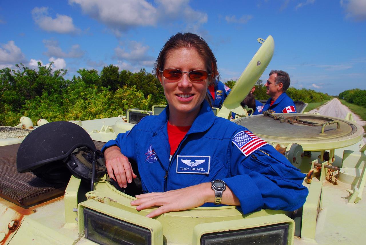 KENNEDY SPACE CENTER, Fla.  --  STS-118 Mission Specialist Tracy Caldwell is ready to take her turn at driving an M-113 armored personnel carrier as part of emergency exit training.  Seen behind her at right is Mission Specialist Dave Williams, who represents the Canadian Space Agency. They and other crew members are at Kennedy for the Terminal Countdown Demonstration Test (TCDT), a dress rehearsal for launch.  TCDT activities include the M-113 training, payload familiarization, emergency egress training at the pad and a simulated launch countdown.  The STS-118 payload aboard Space Shuttle Endeavour includes the S5 truss, a SPACEHAB module and external stowage platform 3. The mission is the 22nd flight to the International Space Station and is targeted for launch on Aug.7.  NASA/George Shelton