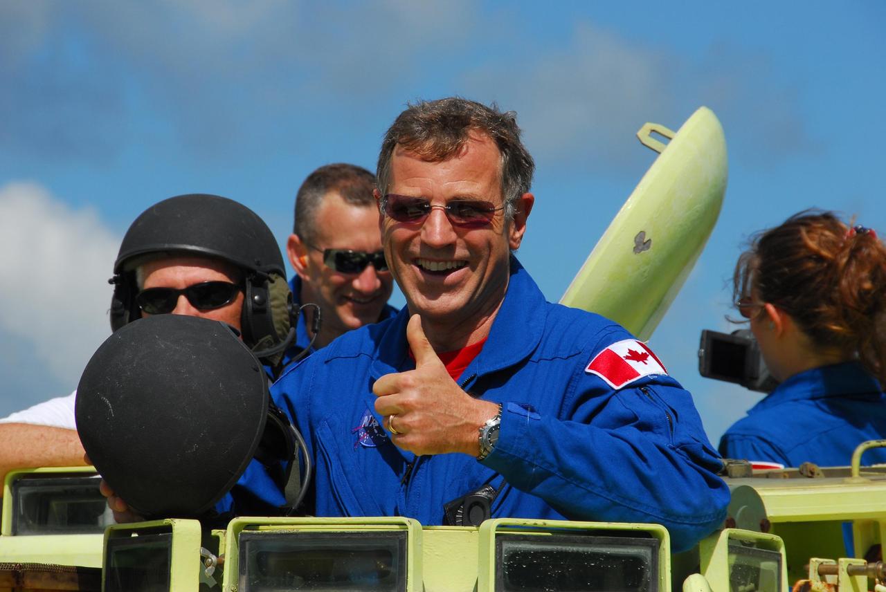 KENNEDY SPACE CENTER, Fla.  --  STS-118 Mission Specialist Dave Williams, who represents the Canadian Space Agency, signals success after driving an M-113 armored personnel carrier as part of emergency exit training.  Behind him are, at left, Pilot Charlie Hobaugh and, right, Mission Specialist Tracy Caldwell. They and other crew members are at Kennedy for the Terminal Countdown Demonstration Test (TCDT), a dress rehearsal for launch.  TCDT activities include the M-113 training, payload familiarization, emergency egress training at the pad and a simulated launch countdown.  The STS-118 payload aboard Space Shuttle Endeavour includes the S5 truss, a SPACEHAB module and external stowage platform 3. The mission is the 22nd flight to the International Space Station and is targeted for launch on Aug.7.  NASA/George Shelton