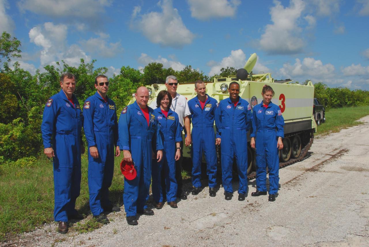 KENNEDY SPACE CENTER, Fla.  --  After completing their driving training on the M-113 armored personnel carrier (behind them), the STS-118 crew take a break.  From left are Mission Specialists Dave Williams and Rick Mastracchio, Commander Scott Kelly, Mission Specialist Barbara R. Morgan, Pilot Charlie Hobaugh, and Mission Specialists Alvin Drew and Tracy Caldwell.  Williams represents the Canadian Space Agency. Morgan joined NASA's Teacher in Space program in 1985 and was selected as an astronaut in 1998.  The crew is at Kennedy for the Terminal Countdown Demonstration Test (TCDT), a dress rehearsal for launch. TCDT activities include the M-113 training, payload familiarization, emergency egress training at the pad and a simulated launch countdown.  The STS-118 payload aboard Space Shuttle Endeavour includes the S5 truss, a SPACEHAB module and external stowage platform 3. The mission is the 22nd flight to the International Space Station and is targeted for launch on Aug.7.  NASA/George Shelton