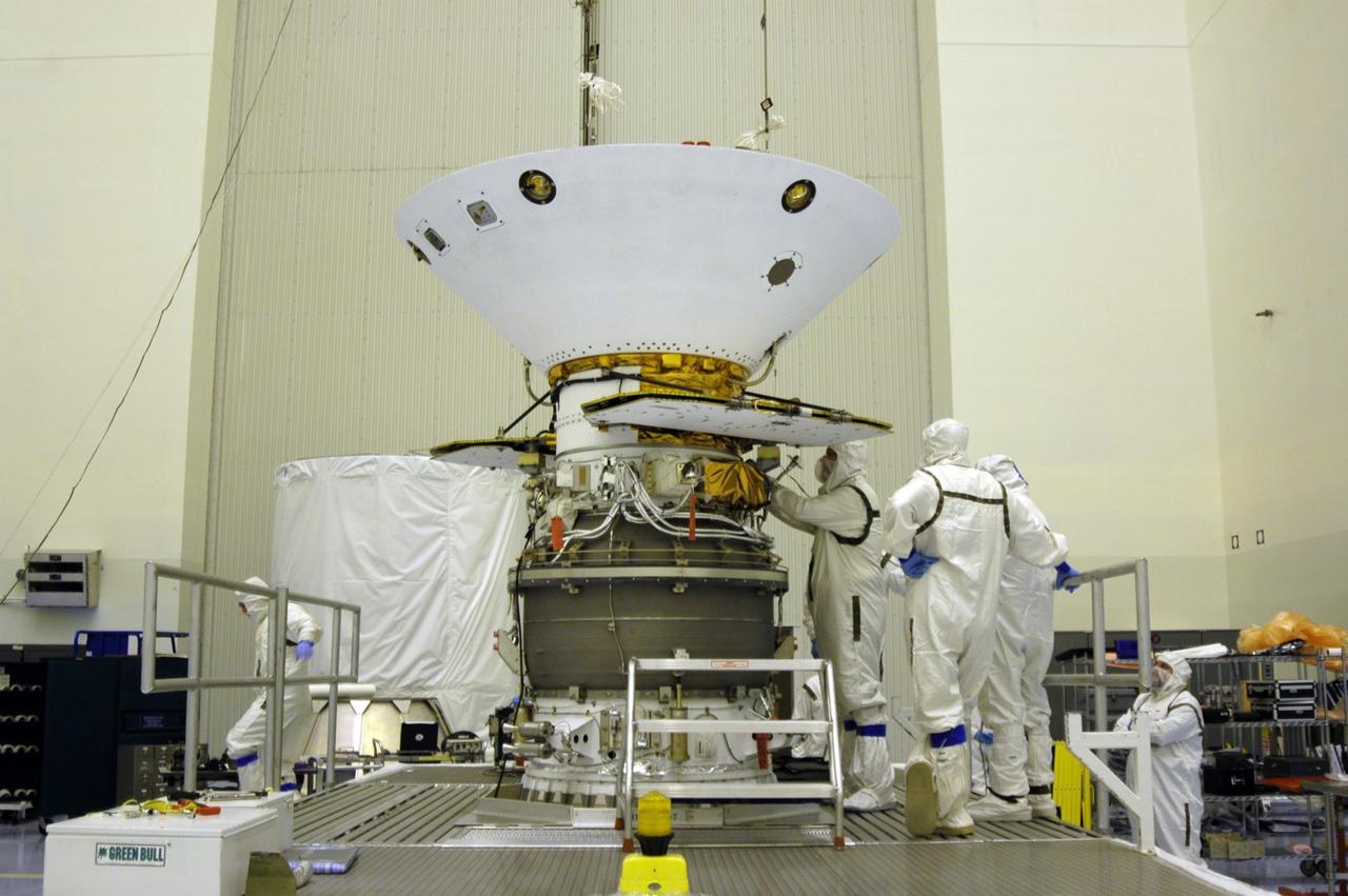 KENNEDY SPACE CENTER, Fla. -- In the Payload Hazardous Servicing Facility, workers secure the Phoenix Mars Lander spacecraft onto the upper stage booster. Targeted for launch from Cape Canaveral Air Force Station on Aug. 3, Phoenix will land in icy soils near the north polar permanent ice cap of Mars and explore the history of the water in these soils and any associated rocks, while monitoring polar climate. Landing on Mars is planned in May 2008 on arctic ground where a mission currently in orbit, Mars Odyssey, has detected high concentrations of ice just beneath the top layer of soil. NASA/Dimitri Gerondidakis