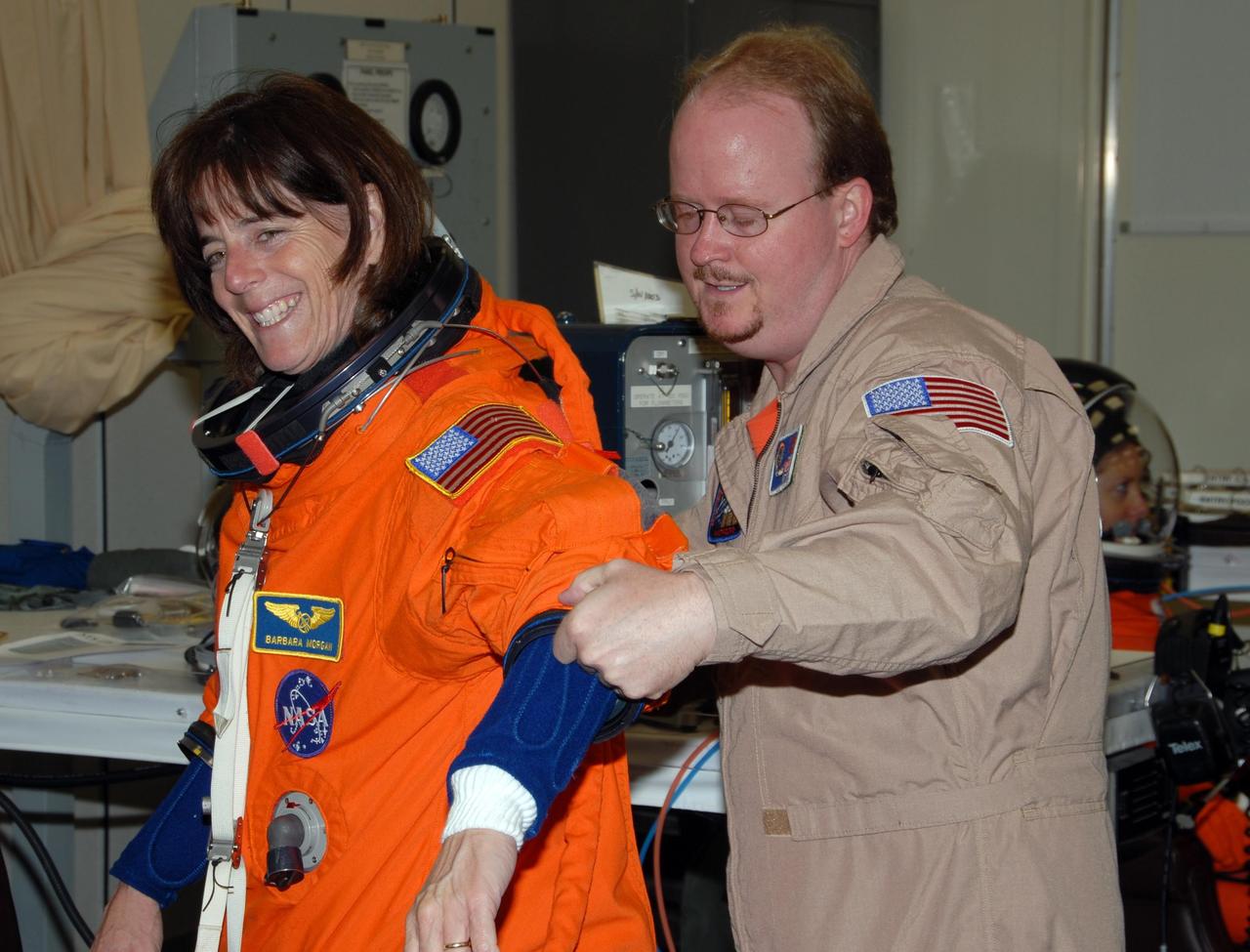 KENNEDY SPACE CENTER, Fla. -- STS-118 Mission Specialist Barbara R. Morgan gets help with the fit of her launch and entry suit during Terminal Countdown Demonstration Test (TCDT) activities, a dress rehearsal for launch. TCDT activities include the M-113 training, payload familiarization, emergency egress training at the pad and a simulated launch countdown. The STS-118 payload aboard Space Shuttle Endeavour includes the S5 truss, a SPACEHAB module and external stowage platform 3. The mission is the 22nd flight to the International Space Station and is targeted for launch on Aug. 7. NASA/George Shelton