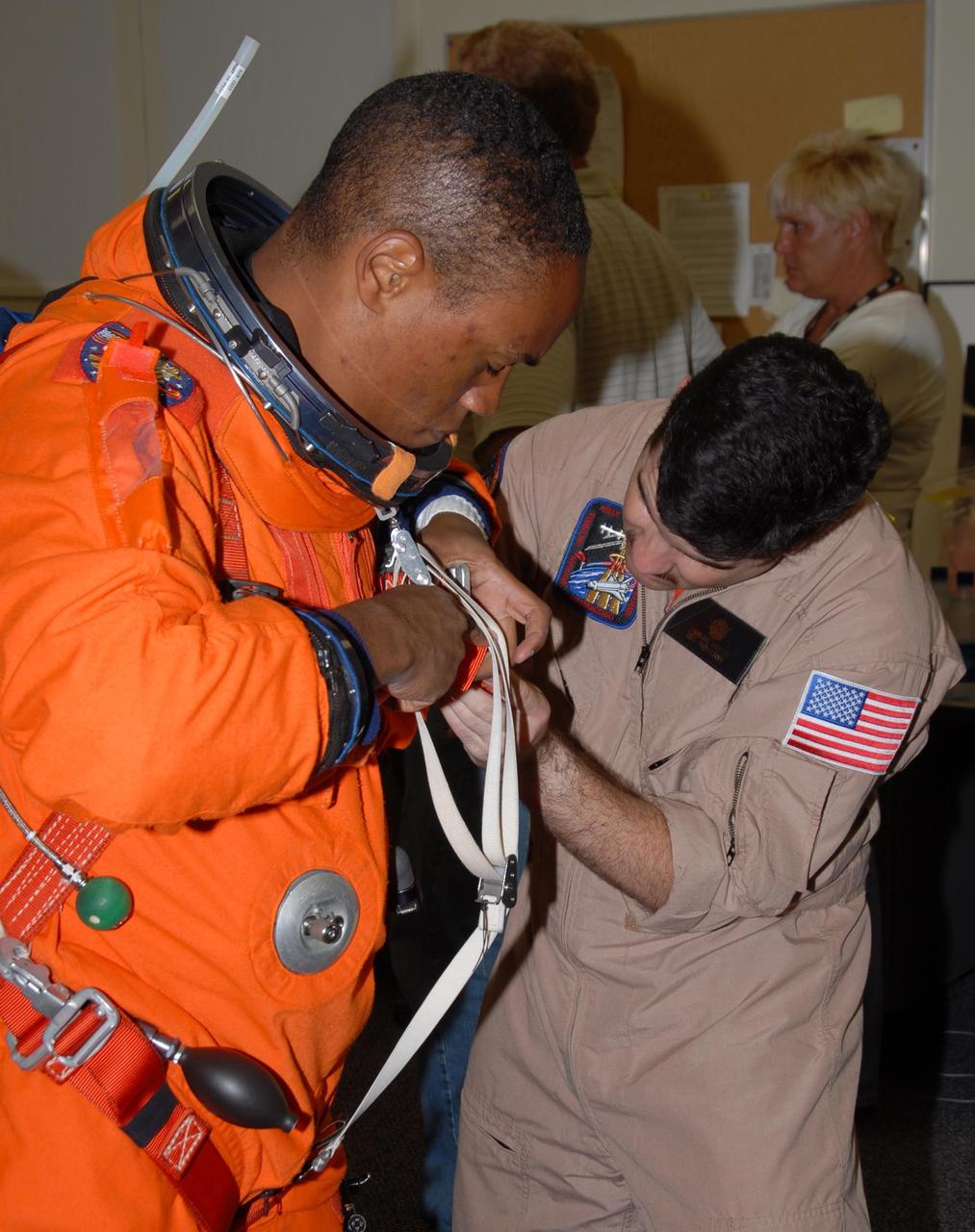 KENNEDY SPACE CENTER, Fla. -- STS-118 Mission Specialist Alvin Drew gets help with the fit of his launch and entry suit during Terminal Countdown Demonstration Test (TCDT) activities, a dress rehearsal for launch. TCDT activities include the M-113 training, payload familiarization, emergency egress training at the pad and a simulated launch countdown. The STS-118 payload aboard Space Shuttle Endeavour includes the S5 truss, a SPACEHAB module and external stowage platform 3. The mission is the 22nd flight to the International Space Station and is targeted for launch on Aug. 7. NASA/George Shelton