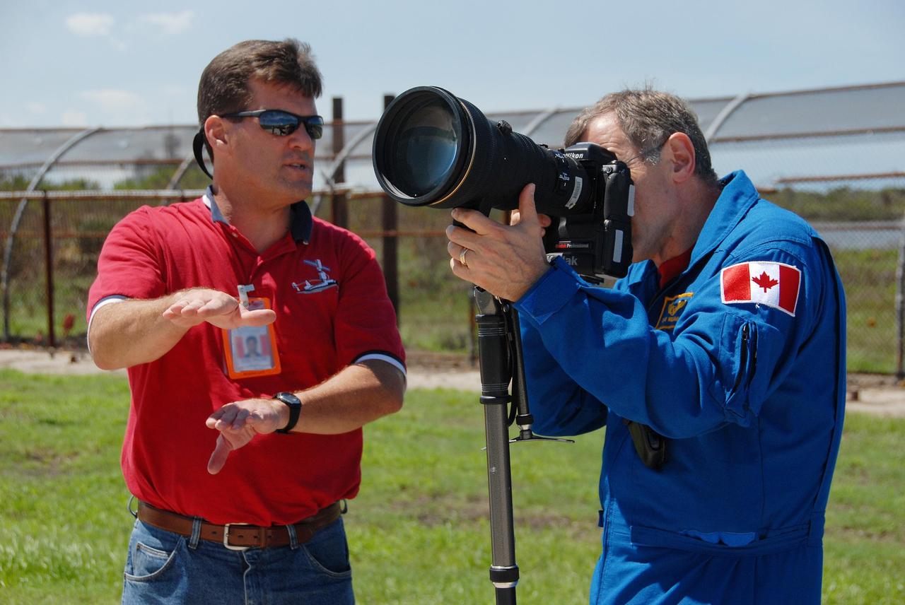 KENNEDY SPACE CENTER, Fla. -- Near Launch Pad 39A, STS-118 Mission Specialist Dave Williams gets pointers from a Johnson Space Center crew photo trainer on using the camera and telephoto lens to photograph the external tank/solid rocket booster stack on Space Shuttle Endeavour. Williams and other mission specialists will take photos of the tank after separation from Endeavour after launch. The STS-118 crew is at Kennedy to take part in Terminal Countdown Demonstration Test activities, including M-113 training, payload familiarization, emergency egress training at the pad and a simulated launch countdown. The payload aboard Space Shuttle Endeavour includes the S5 truss, a SPACEHAB module and external stowage platform 3. The STS-118 mission is the 22nd flight to the International Space Station and is targeted for launch on Aug. 7. NASA/George Shelton