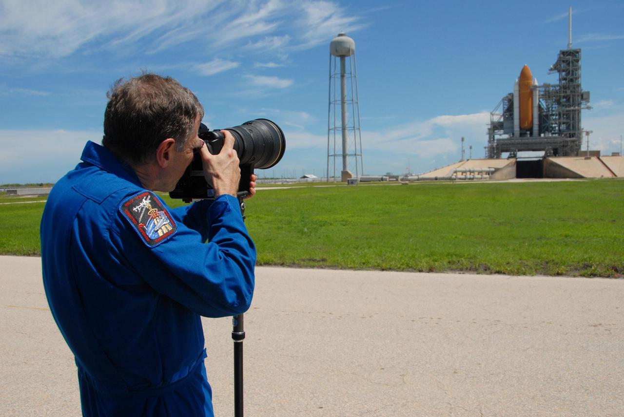 KENNEDY SPACE CENTER, Fla. -- Near Launch Pad 39A, STS-118 Mission Specialist Dave Williams practices using the camera and telephoto lens to photograph the external tank/solid rocket booster stack on Space Shuttle Endeavour. Williams and other mission specialists will take photos of the tank after separation from Endeavour after launch. The STS-118 crew is at Kennedy to take part in Terminal Countdown Demonstration Test activities, including M-113 training, payload familiarization, emergency egress training at the pad and a simulated launch countdown. The payload aboard Space Shuttle Endeavour includes the S5 truss, a SPACEHAB module and external stowage platform 3. The STS-118 mission is the 22nd flight to the International Space Station and is targeted for launch on Aug. 7. NASA/George Shelton